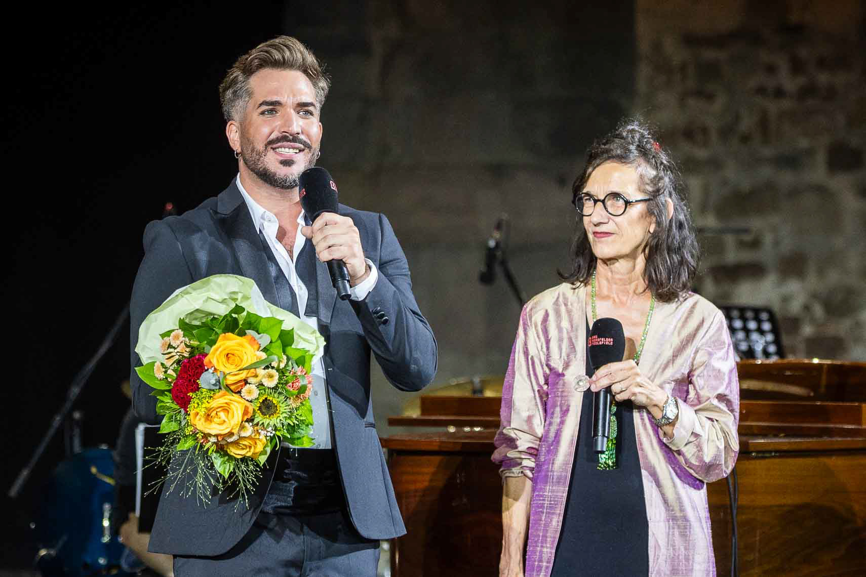 Riccardo Greco bei der Verleihung des Zuschauerpreis durch Elke Hesse (Direktorin und Intendantin der Bad Hersfelder Festspiele) bei der Abschlussgala der 75. Bad Hersfelder Festspiele in der Stiftsruine in Bad Hersfeld, Deutschland, 16. August 2026