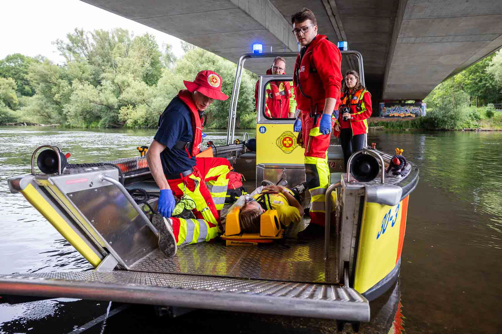 Einsatzkräfte der ASB-Wasserrettung proben auf und an der Fulda unter realistischen Bedingungen den Ernstfall: Im Rahmen der dritten ASB-Bundesübung trainieren über 900 Helferinnen und Helfer aus ganz Deutschland gemeinsam mit Partnerorganisationen wie DRK und Johanniter-Unfall-Hilfe verschiedene Katastrophenszenarien. Für das leibliche Wohl sorgt das Weiße Kreuz Südtirol mit einer mobilen Großküche. Ziel der Übung ist es, Abläufe zu optimieren und die Zusammenarbeit im Bevölkerungsschutz zu stärken, aufgenommen am 27. Juni 2025 in Kassel (Hessen).