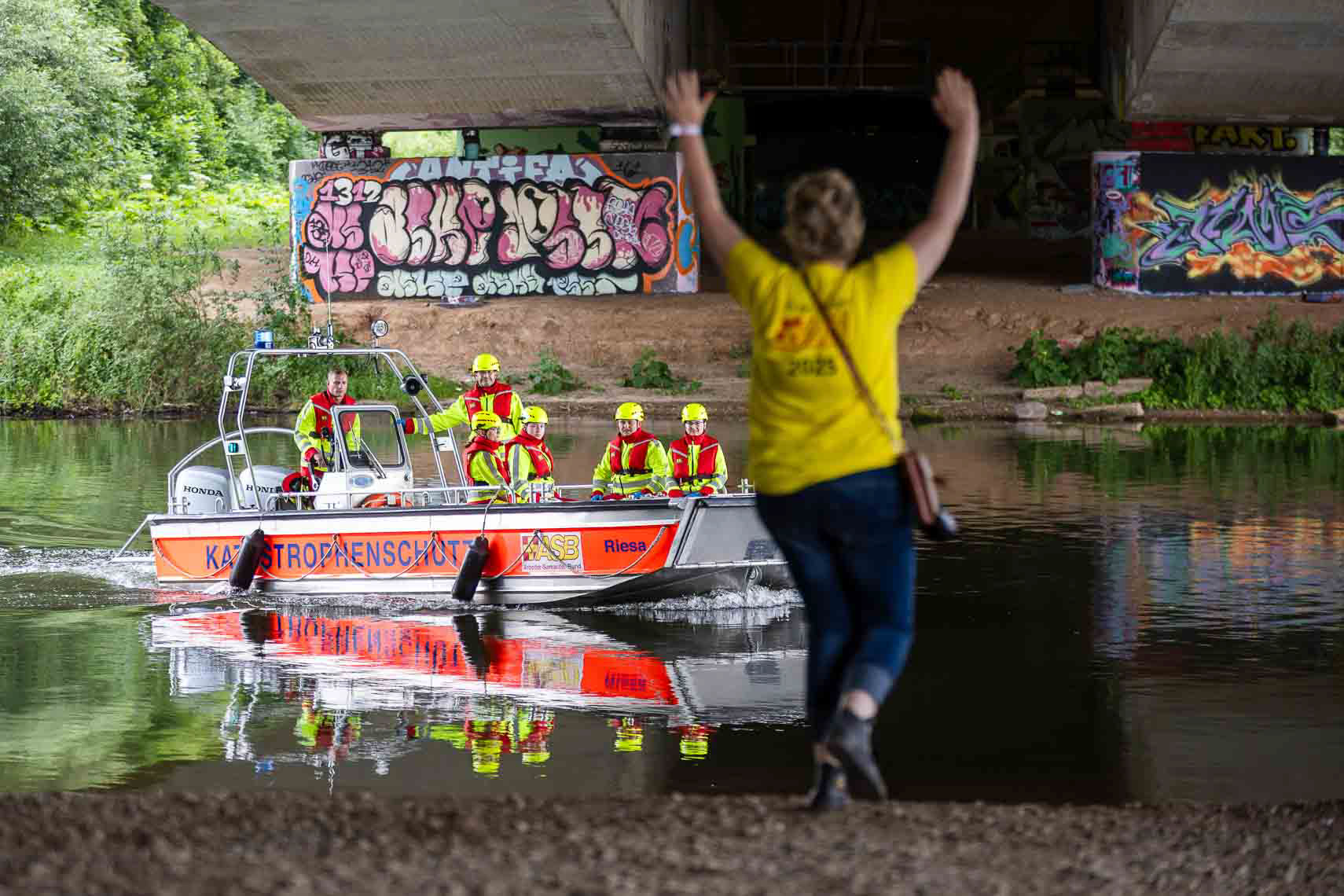 Einsatzkräfte der ASB-Wasserrettung proben auf und an der Fulda unter realistischen Bedingungen den Ernstfall: Im Rahmen der dritten ASB-Bundesübung trainieren über 900 Helferinnen und Helfer aus ganz Deutschland gemeinsam mit Partnerorganisationen wie DRK und Johanniter-Unfall-Hilfe verschiedene Katastrophenszenarien. Für das leibliche Wohl sorgt das Weiße Kreuz Südtirol mit einer mobilen Großküche. Ziel der Übung ist es, Abläufe zu optimieren und die Zusammenarbeit im Bevölkerungsschutz zu stärken, aufgenommen am 27. Juni 2025 in Kassel (Hessen).
