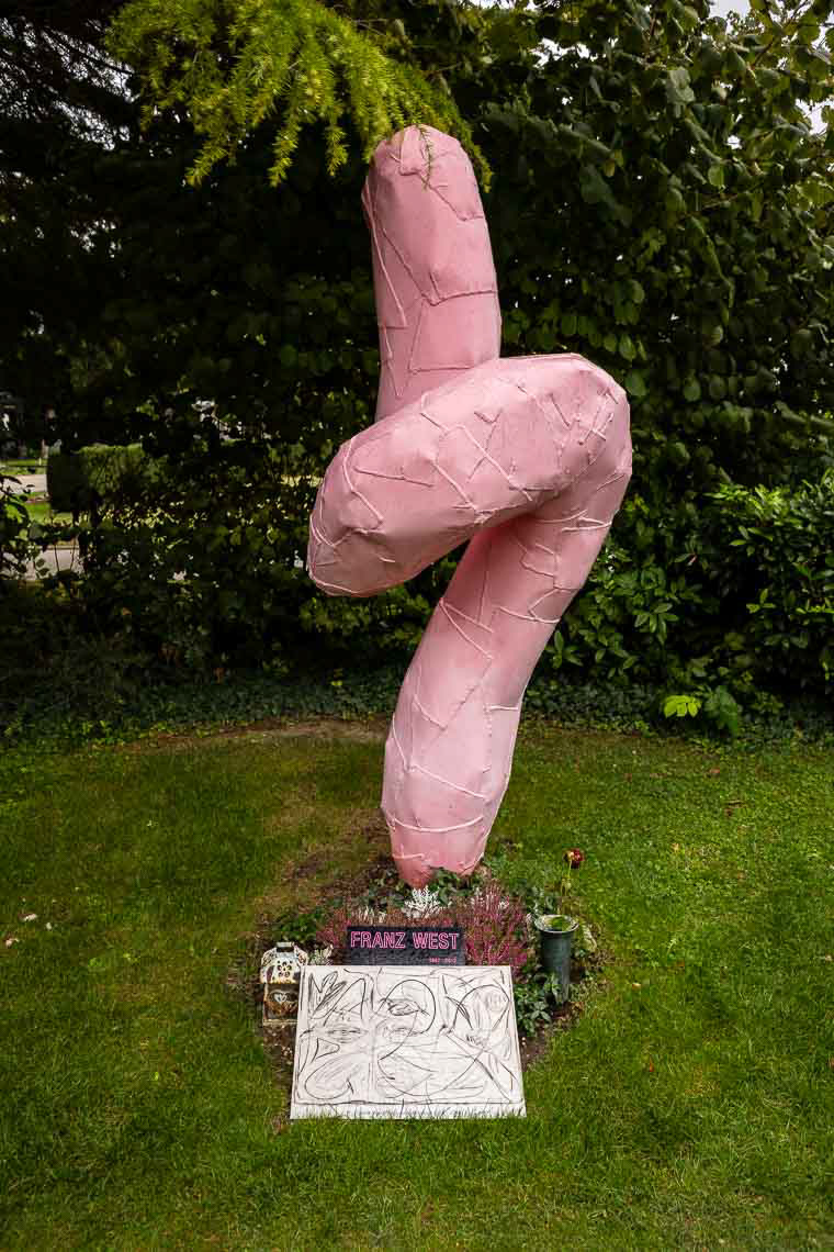Grabstätte von Künstler Franz West (1947 - 2012) mit rosaroter Skulptur die zum Nachdenken anregen soll auf dem Zentralfriedhof Wien.
