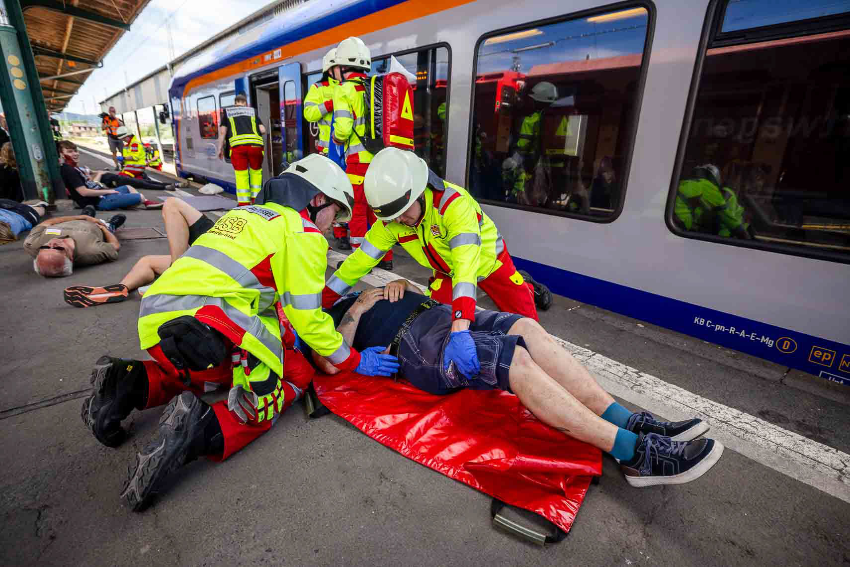 Im Rahmen der ASB-Bundesgroßübung wurde am Hauptbahnhof Kassel ein schwerer Bahnunfall mit zahlreichen Verletzten simuliert. Einsatzkräfte von ASB und anderen Hilfsorganisationen koordinierten die Evakuierung, Erstversorgung und den Abtransport der Betroffenen. Ziel der Übung war die Verbesserung der Zusammenarbeit und Transportlogistik bei einem Massenanfall von Verletzten. 27. Juni 2025, Kassel / Hessen / Deutschland