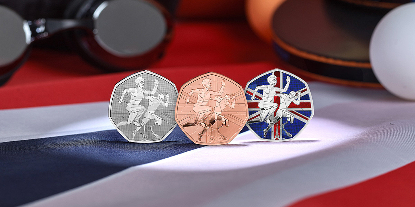 Three commemorative coins displaying athletic figures in geometric mosaic style, arranged on a Union Jack flag surface. From left to right: a silver coin, a copper coin, and a colorized coin featuring the Union Jack design with dynamic angular athlete silhouettes.