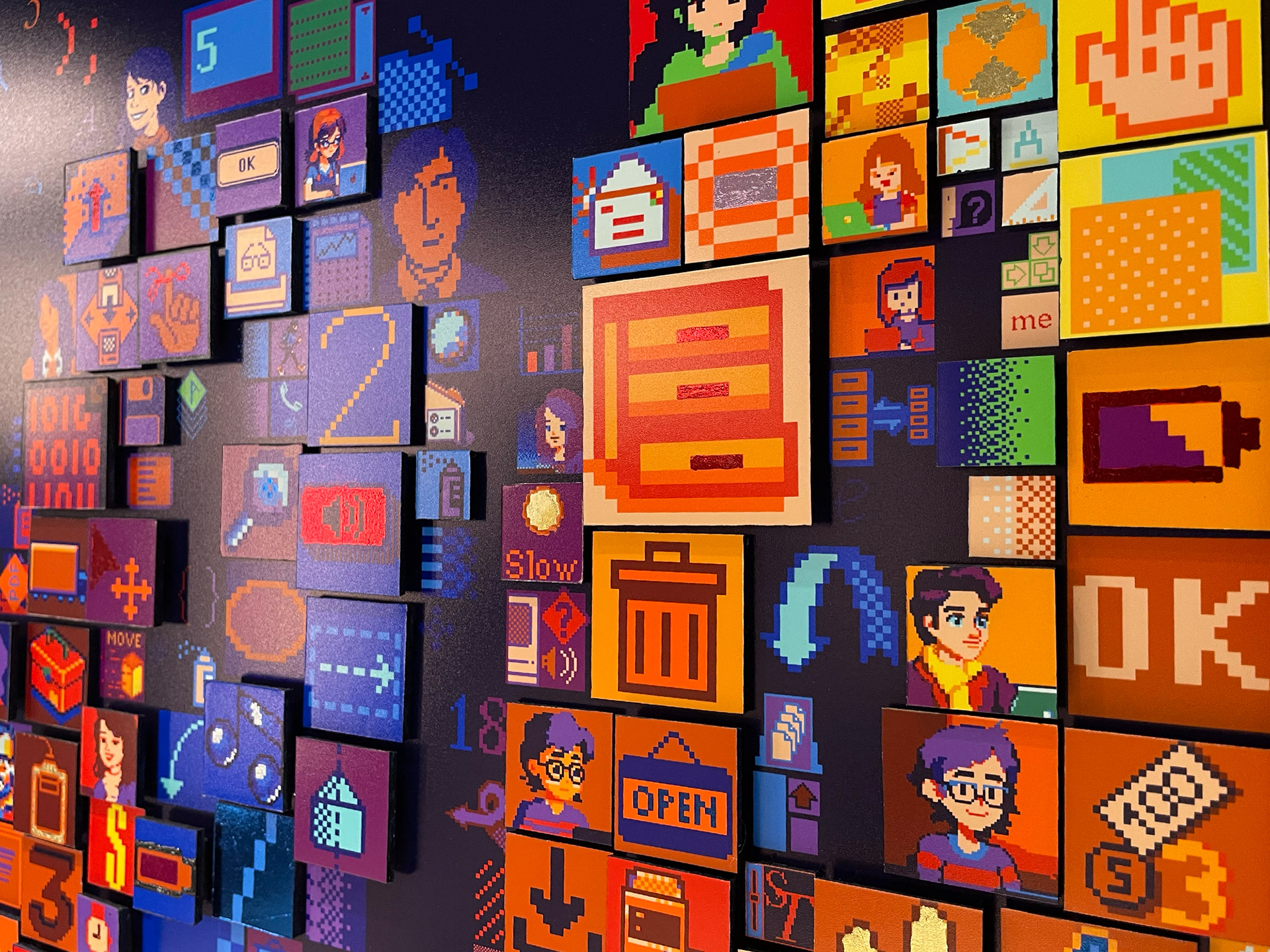 Detailed close-up of Charis Tsevis' digital mosaic "HELLO" artwork for Apple headquarters showing pixelated interface elements including Susan Kare's iconic designs, Macintosh interfaces, and modern digital symbols spanning four decades of Apple's history