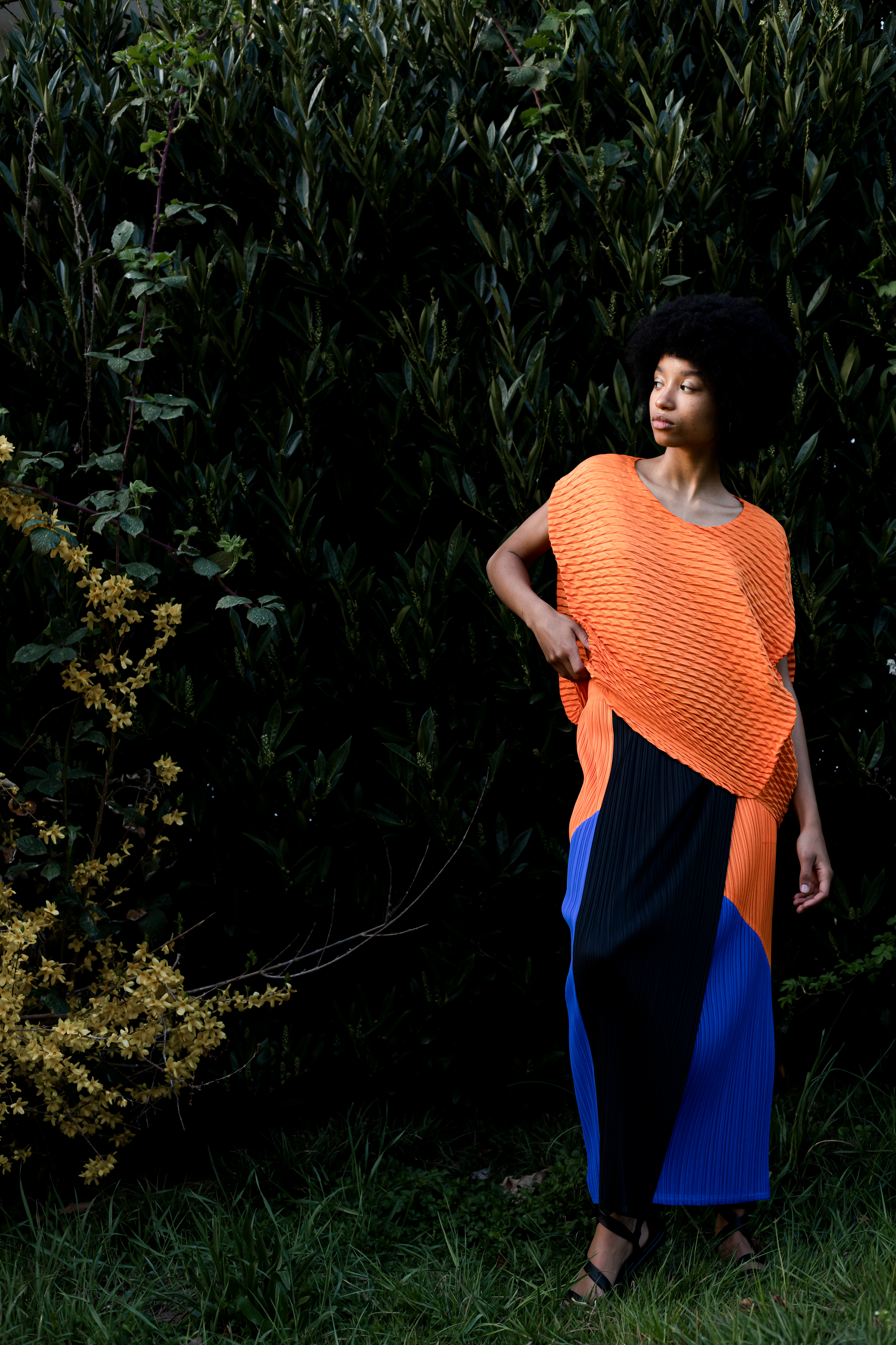 Jupe plissée tricolore en polyester Pleats Please Issey Miyake. Top orange en polyester Issey Miyake. © Aurélie Nydegger - Modèle Inès