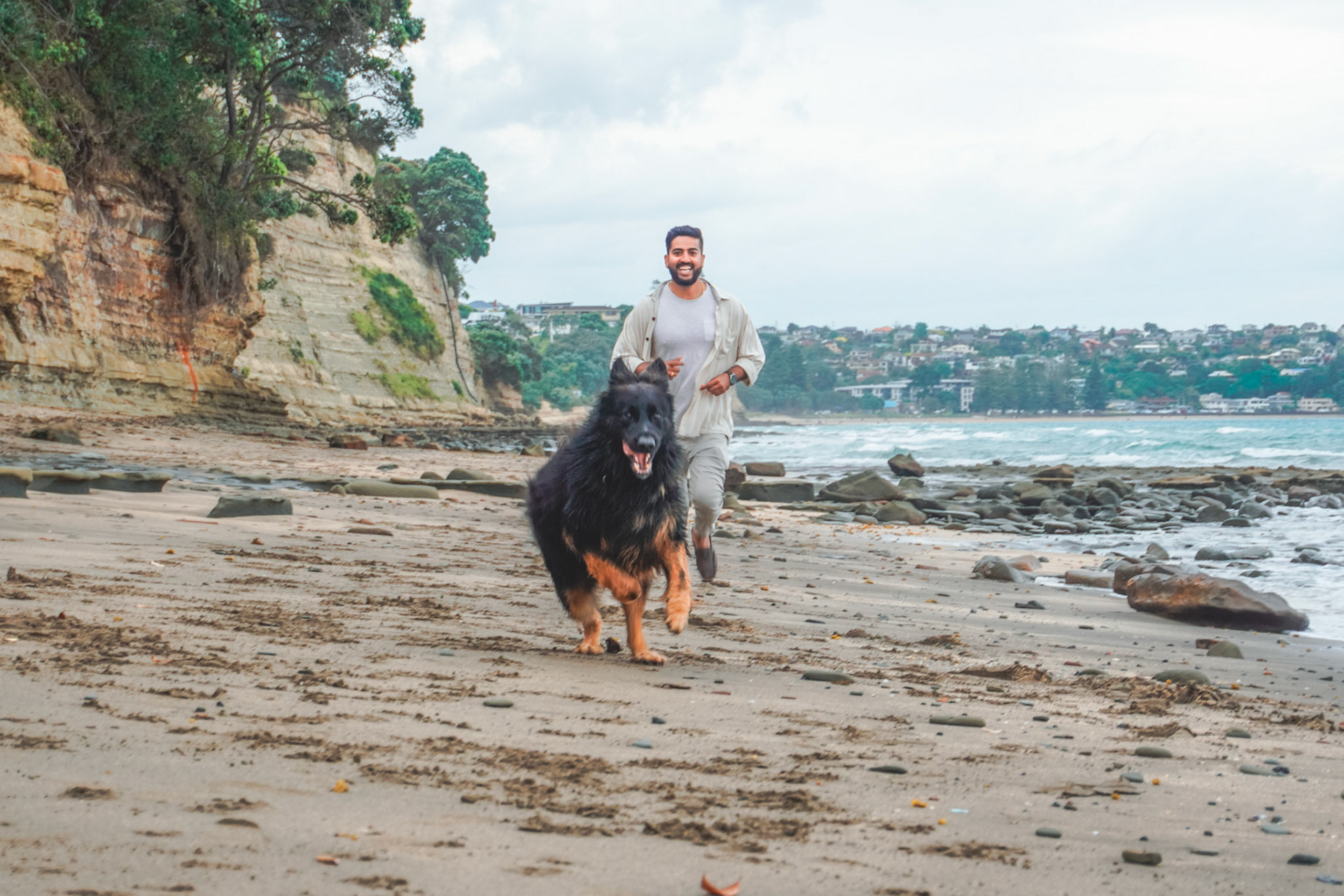 Running on a beach, with a dog, happiness on a New Zealand beach