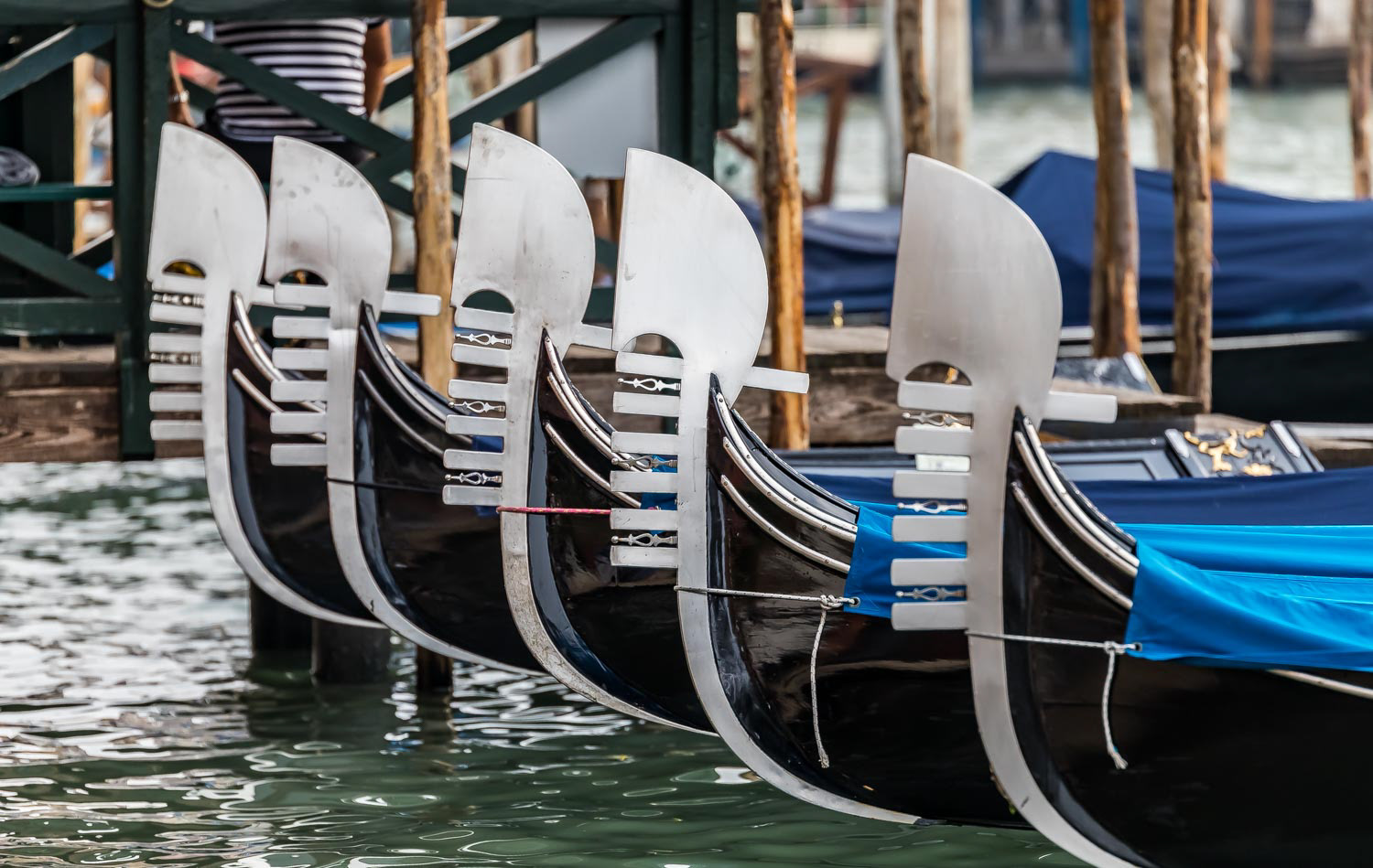 Gondolas lined up in Venice Italy with focus on nose decoration ferro
