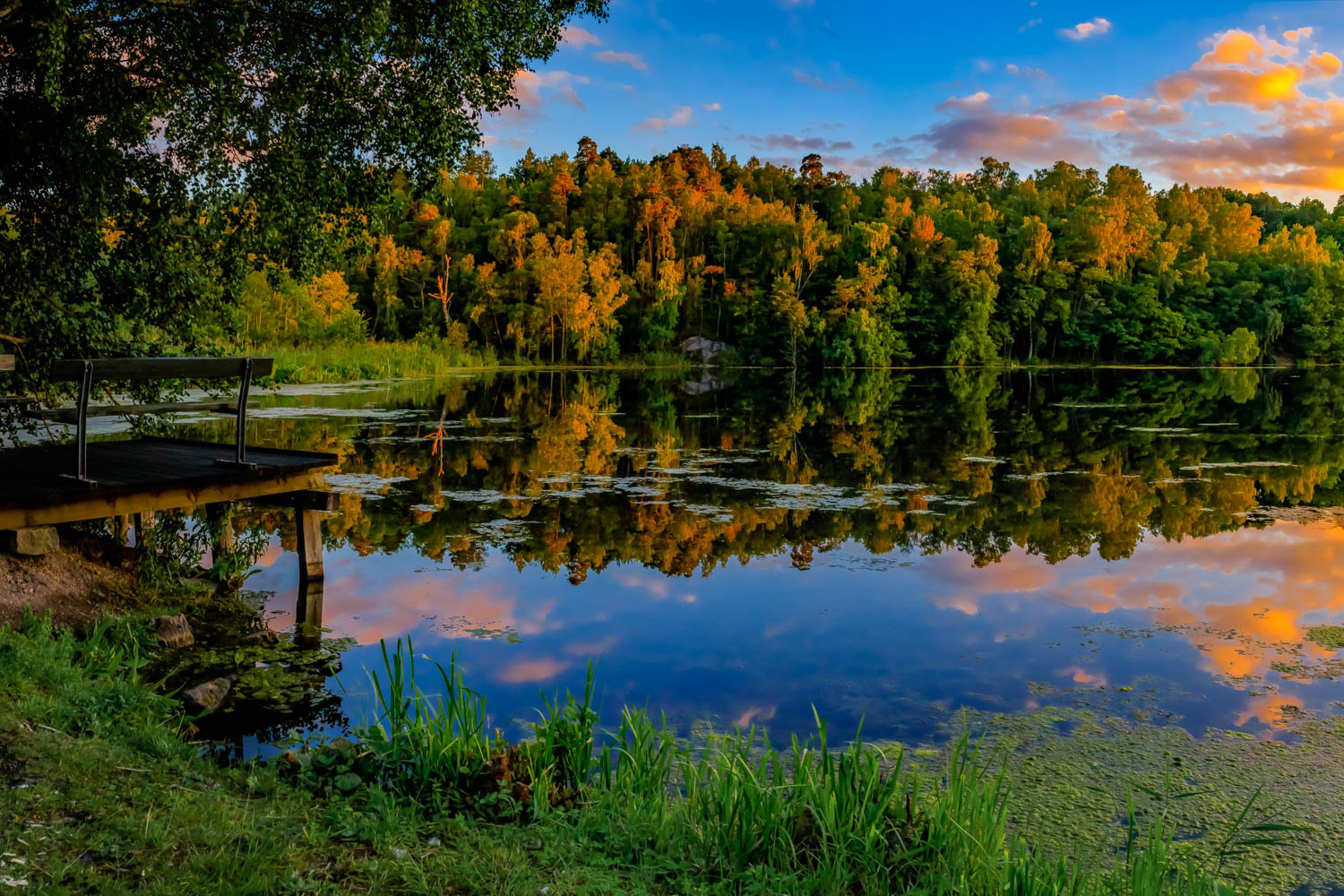Beautiful landscape with a colorful sunset over a lake with a wooden pier