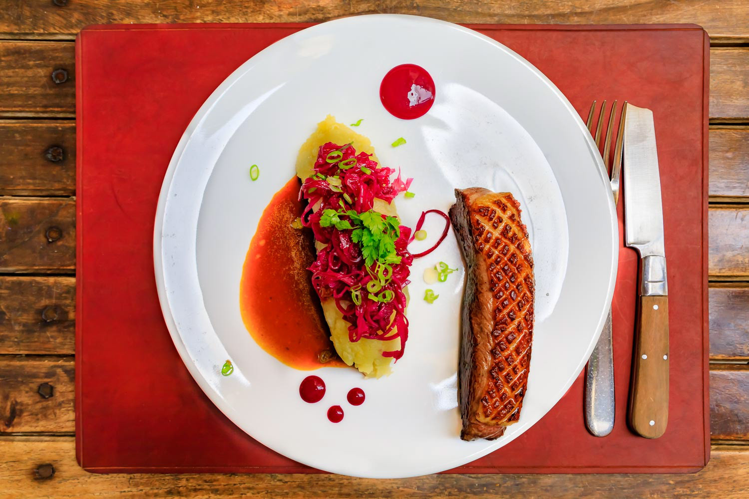 Seared duck breast with mashed potatoes and pickled cabbage at a French restaurant