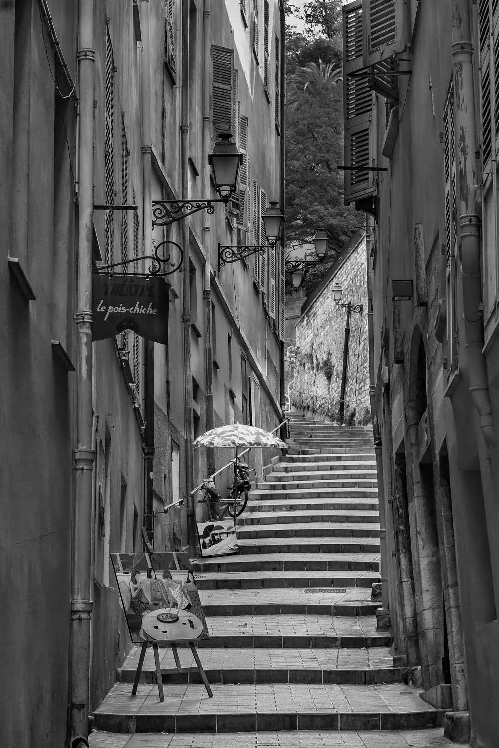 Narrow crooked street in the Old Town, Vieille Ville in Nice, French Riviera in black and white