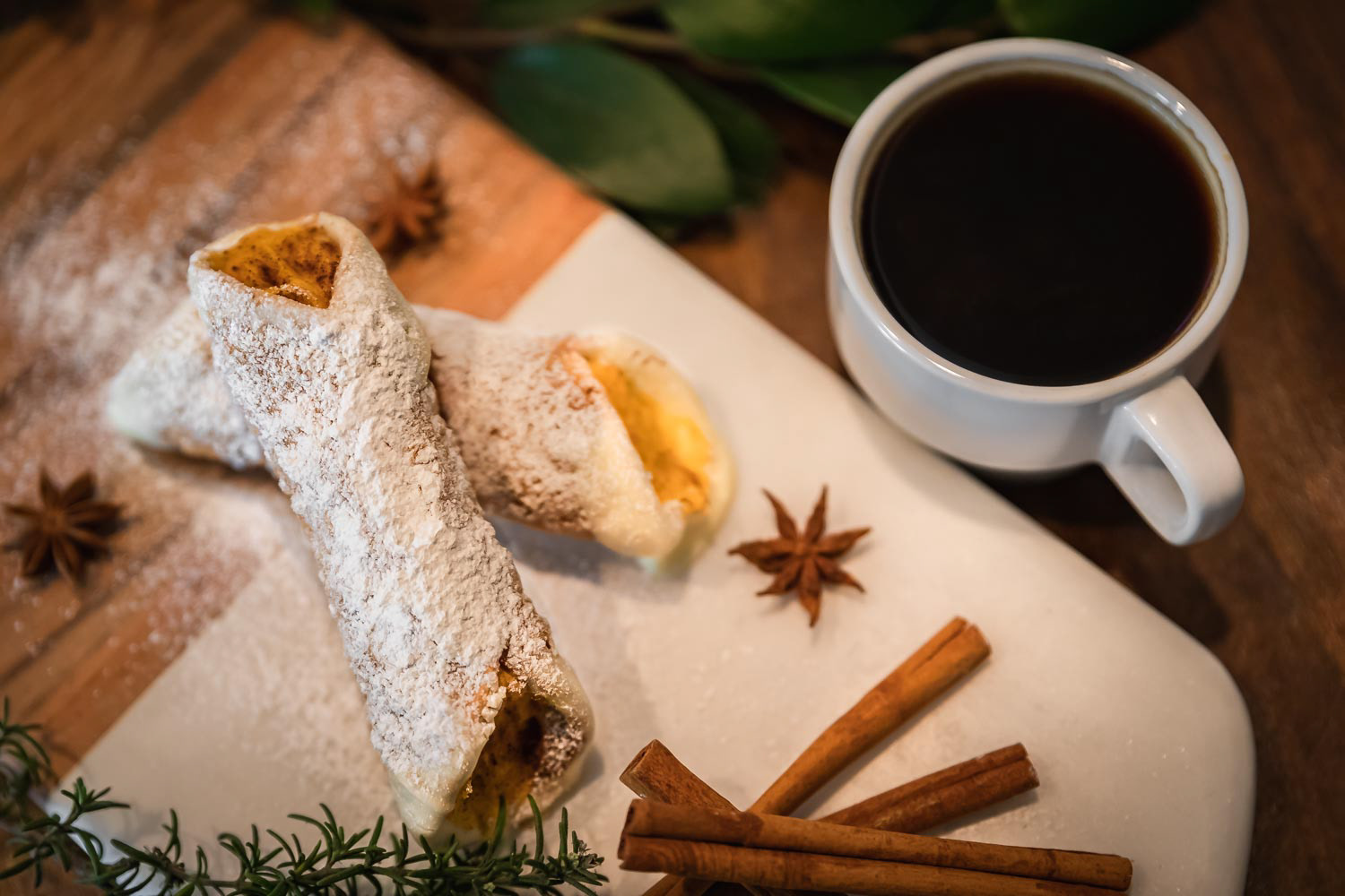 Pumpkiln cannolli on a wooden platter with a glass of rose champagne