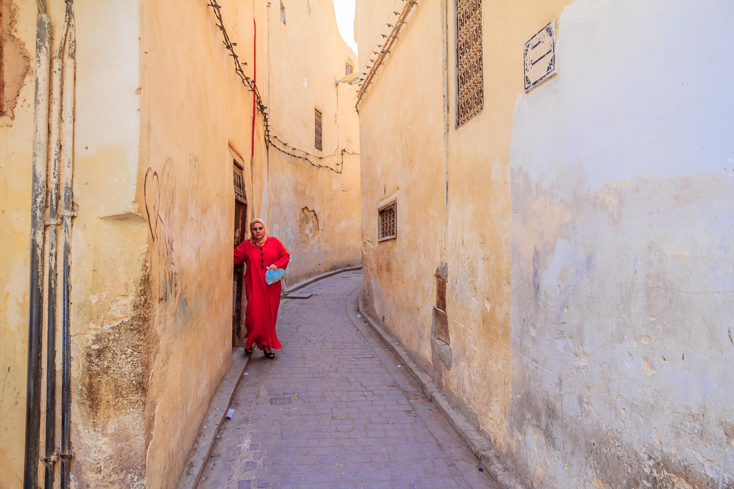 Woman walking out into a narrow street in the medina
