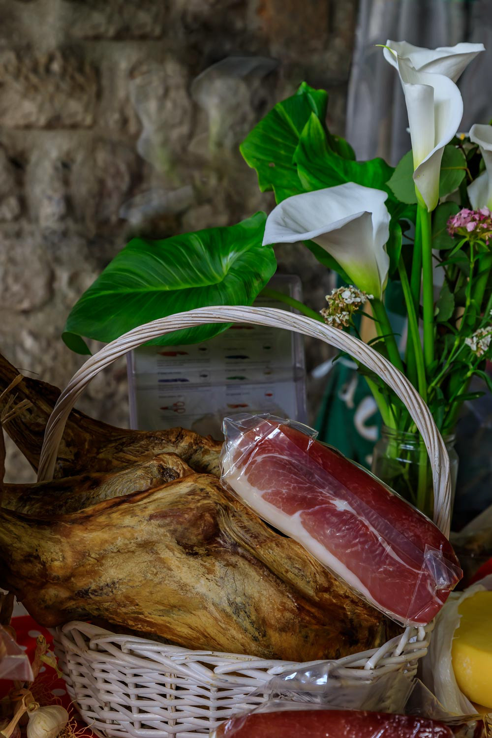 Whole bone-in ham leg of Montenegrin Njeguski prsut cured ham and sliced packaged meat at a market in Kotor Montenegro