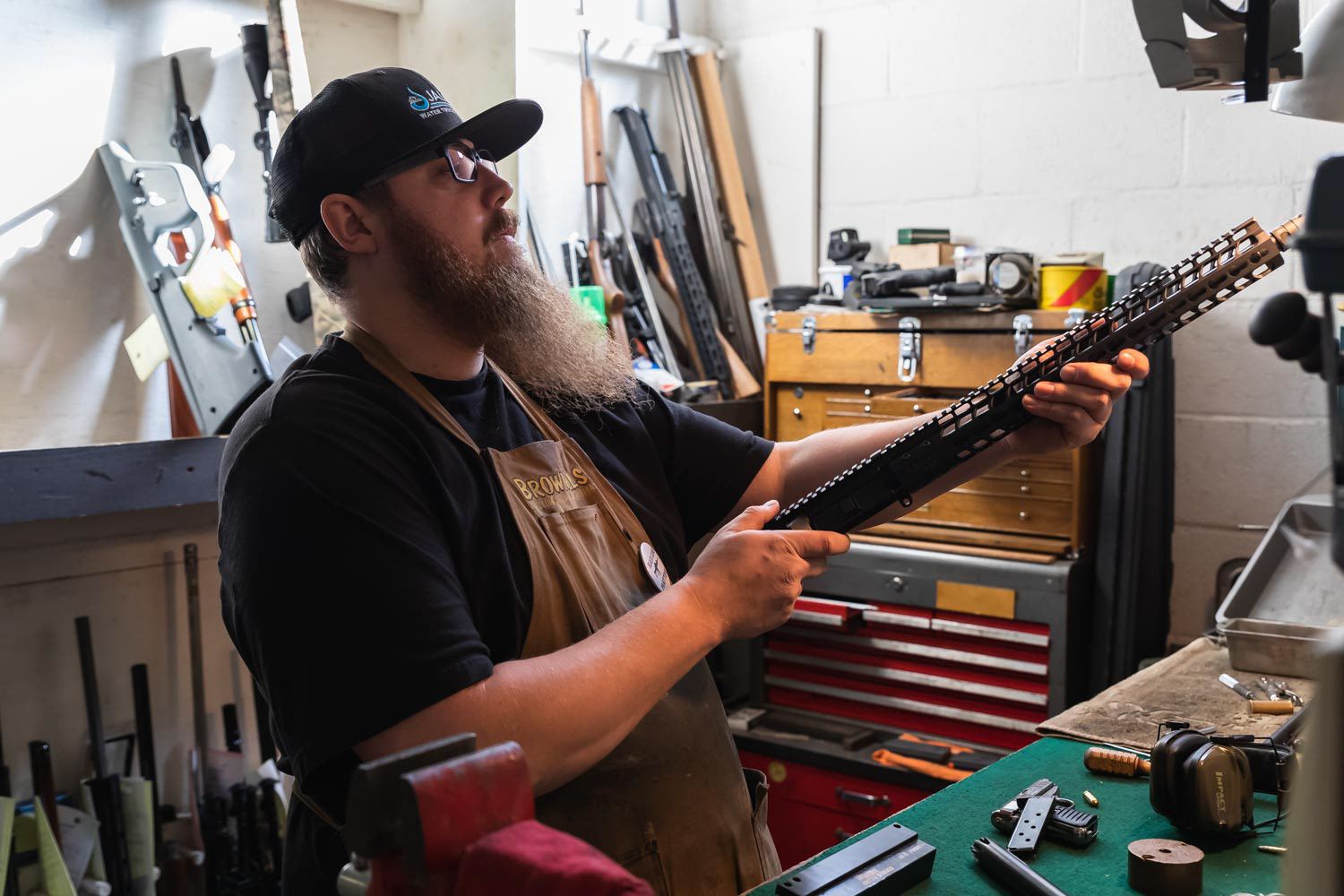 Gunsmith working on an 300 Blackout AR rifle upper receiver in a gun shop in California