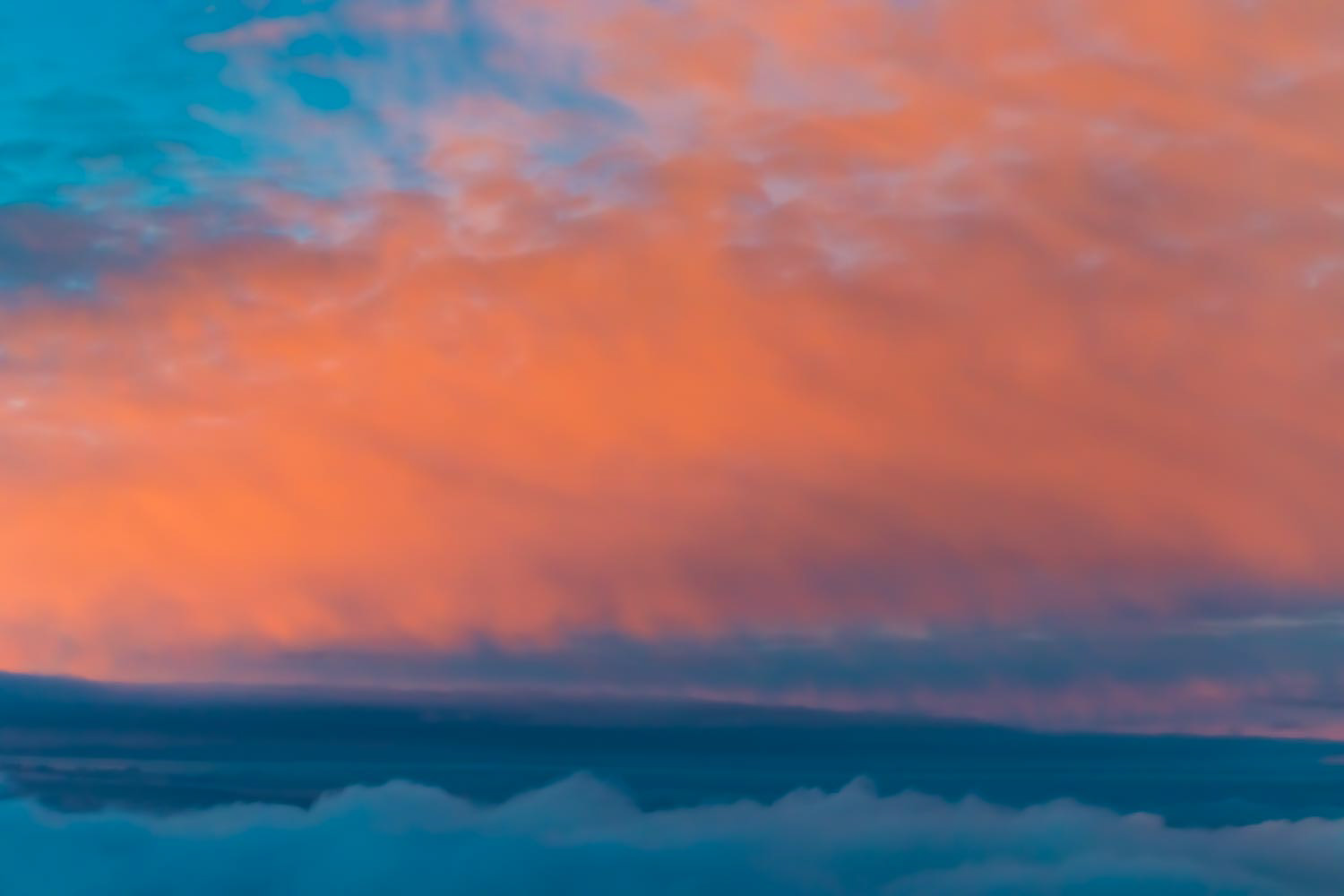 Colorful fluffy clouds outside an airplane at sunset