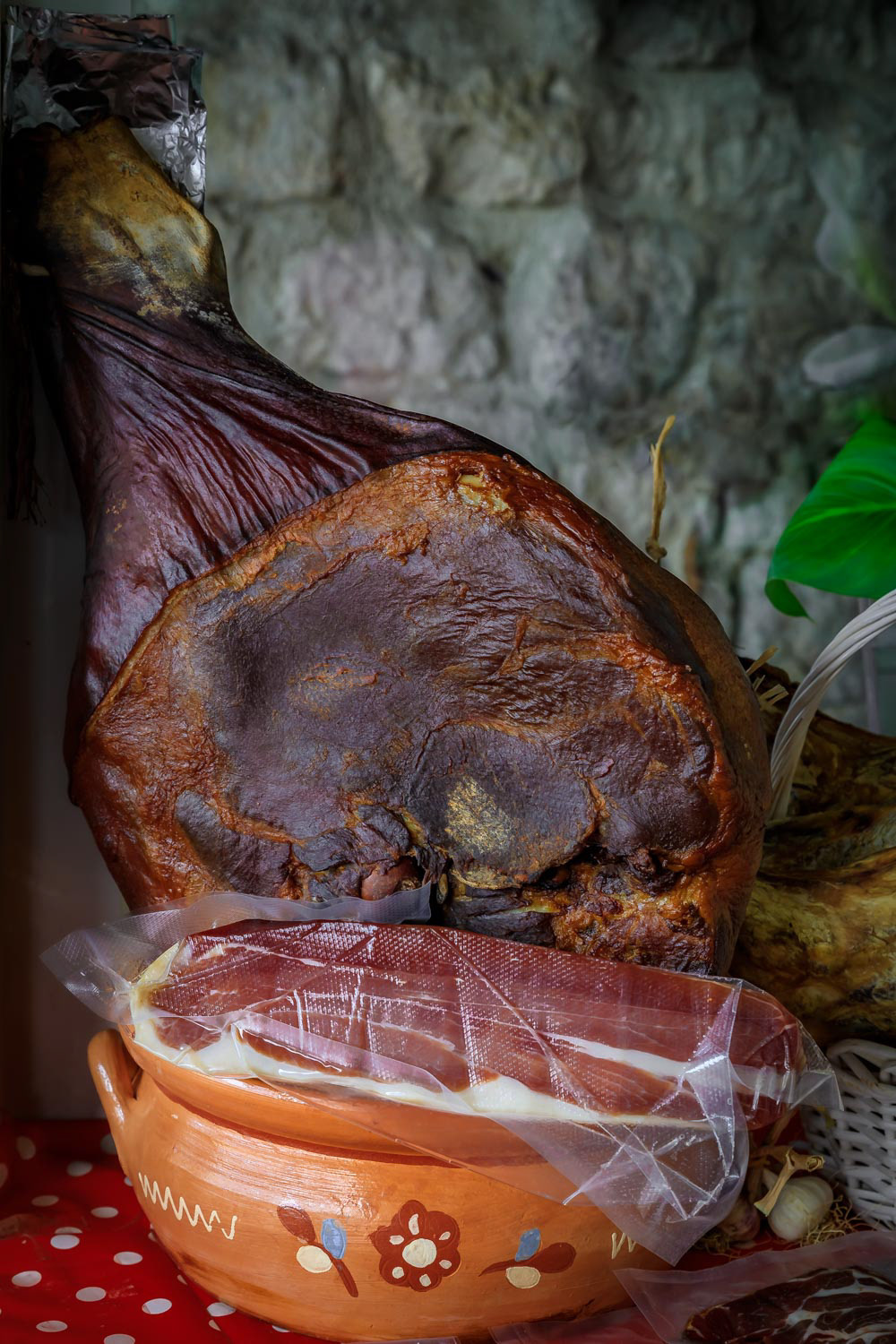 Whole bone-in ham leg of Montenegrin Njeguski prsut cured ham and sliced packaged meat at a market in Kotor Montenegro