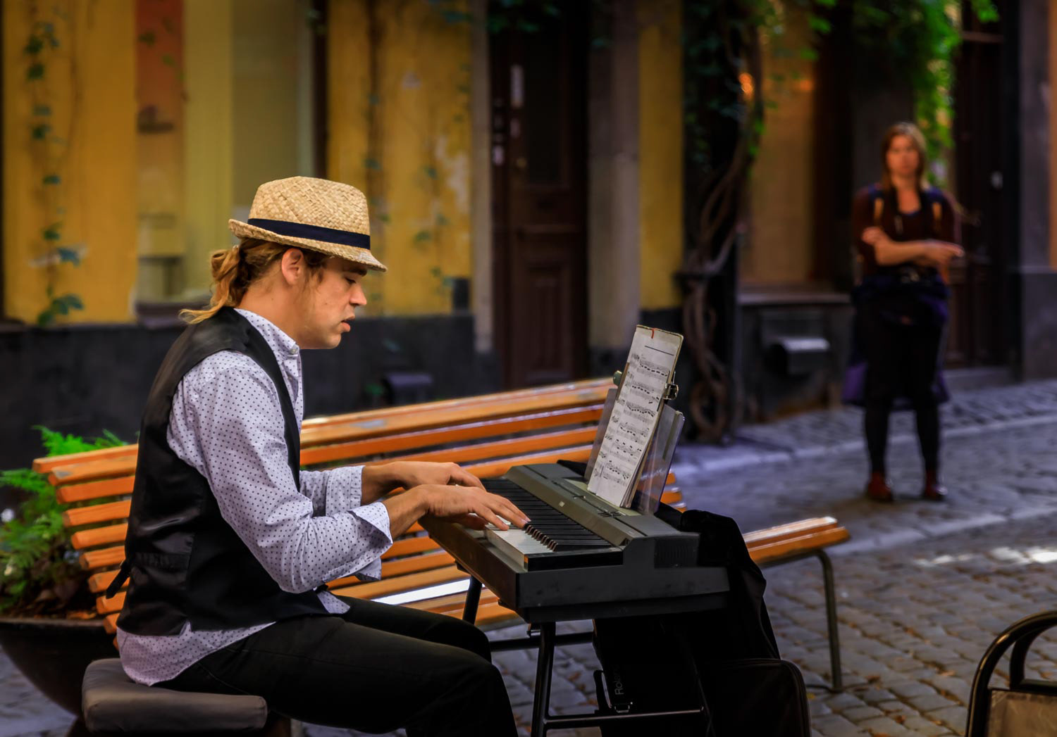 Street musician, electric keyboard player, playing for tourists in the middle of Gamla Stan old town, Stockholm, Sweden