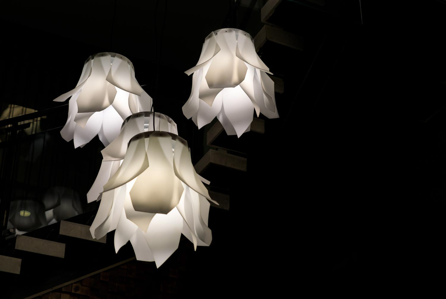 Modern opaque white abstract floral shaped light fixtures hanging from the ceiling