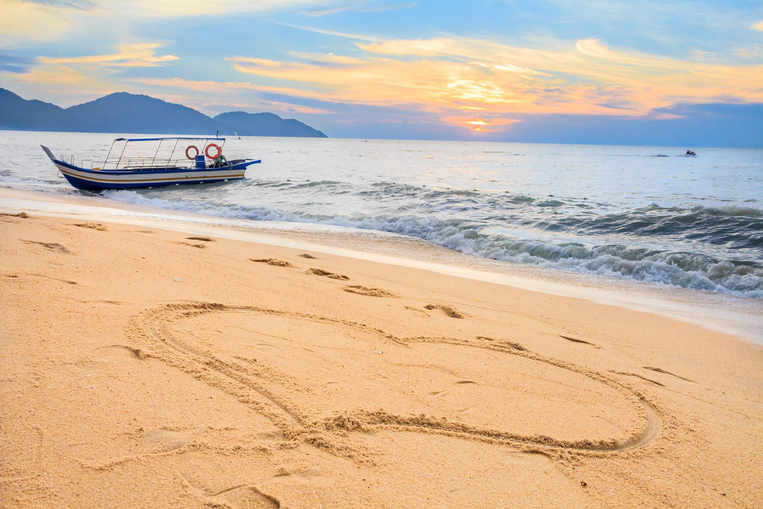 Heart in the sand on a tropical Batu Feringghi beach in Penang, Malaysia