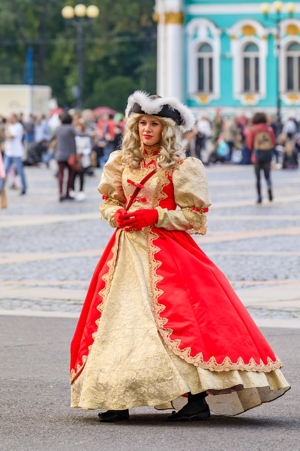 Female entertainer in period dress awaiting tourists by the Hermitage Winter Palace on Palace Square Saint Petersburg, Russia