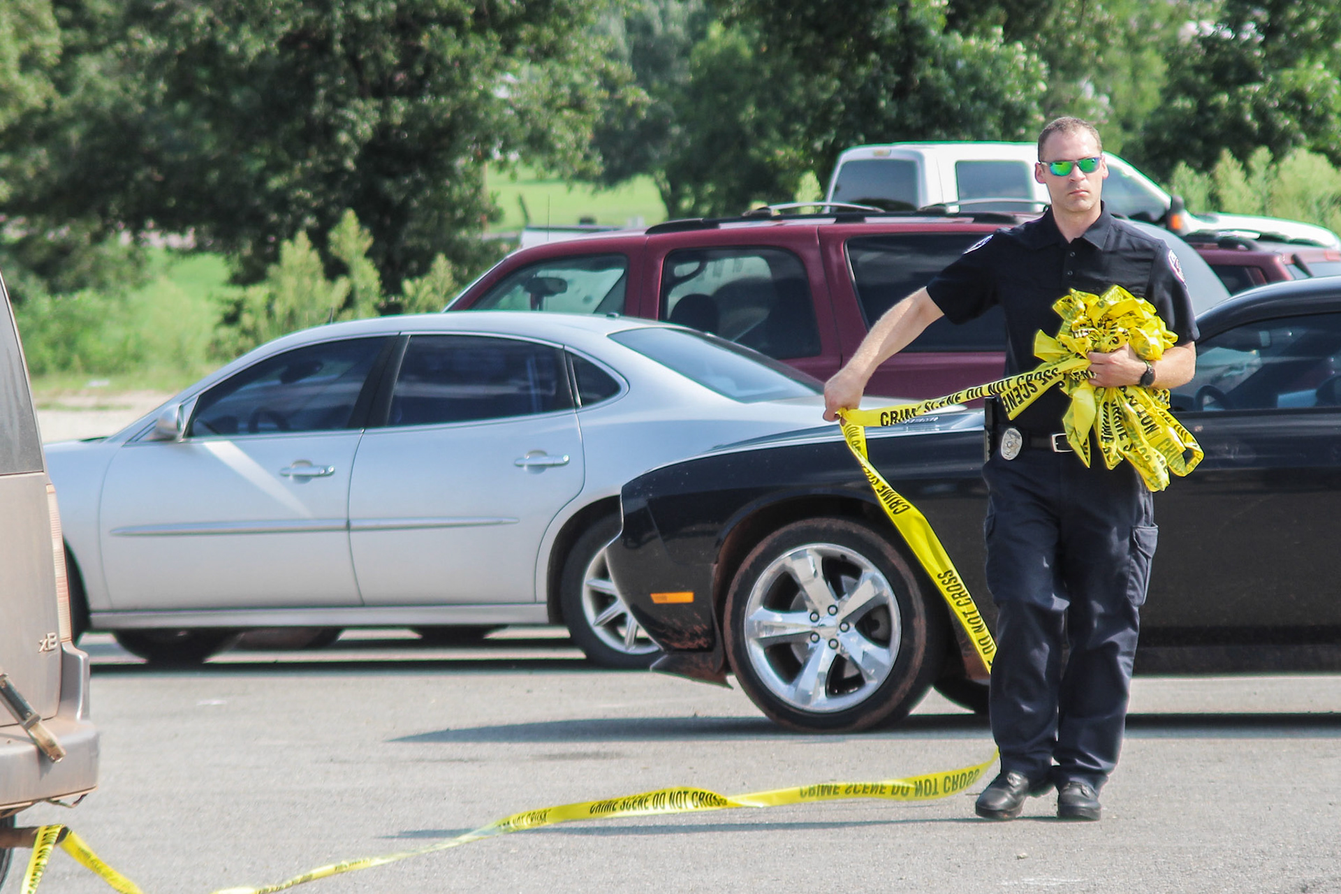 Luther police deputy chief Tony Walker removes crime scene tape at Luther High School at the end of the school day after a freshman student stabbed another student on the first day of school. (Luther Register News)