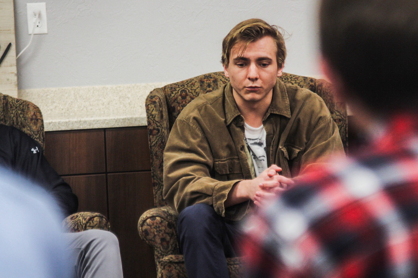 OBU swimmer Jake Usry sits in solace at a memorial service for his swim coach Sam Freas after his unexpected death the previous week. (The Bison)