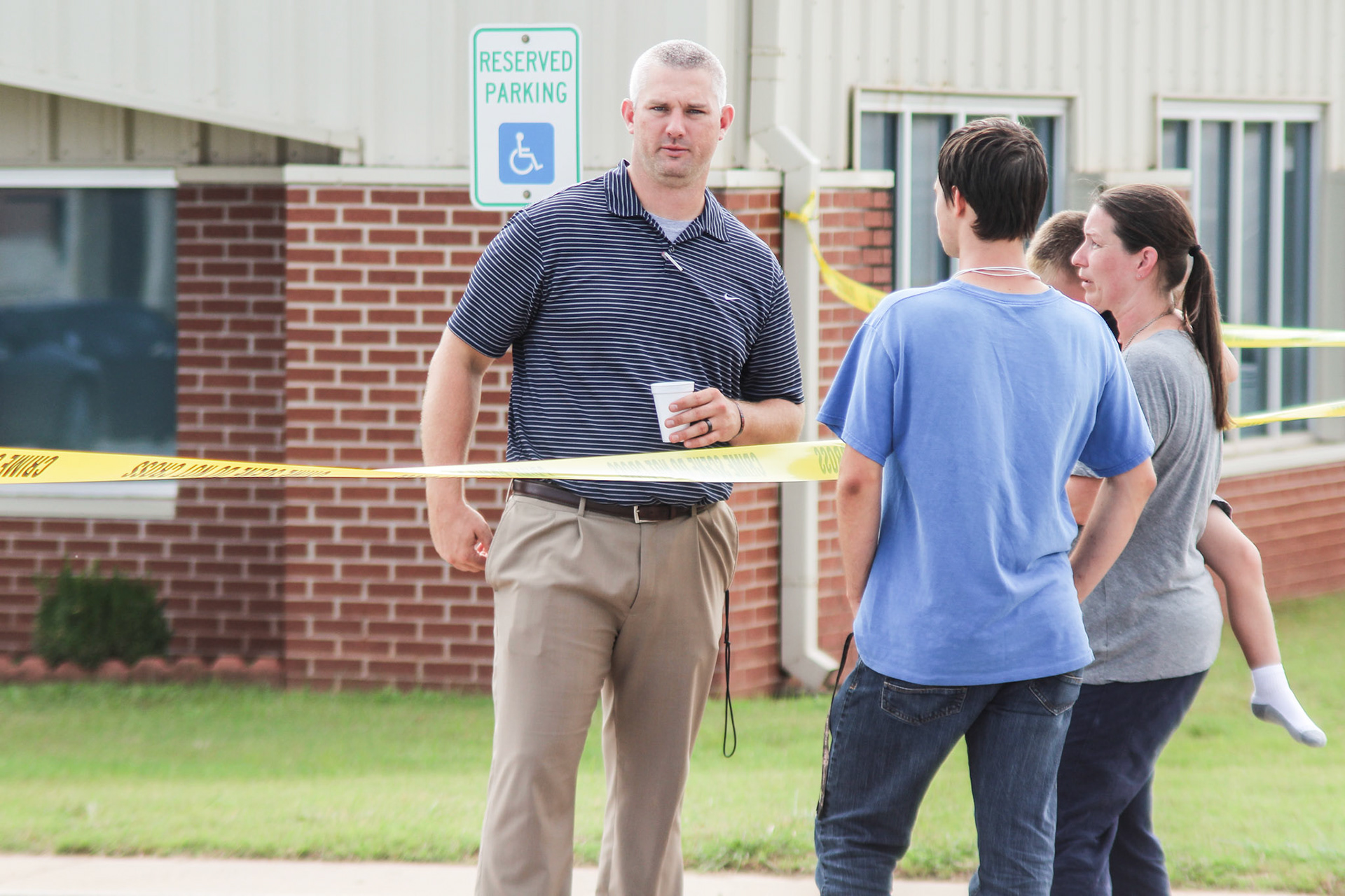 Luther High School principal Shawn Meek talks to a parent after a freshman student stabs another student on the first day of the 2018-2019 school year. (Luther Register News)