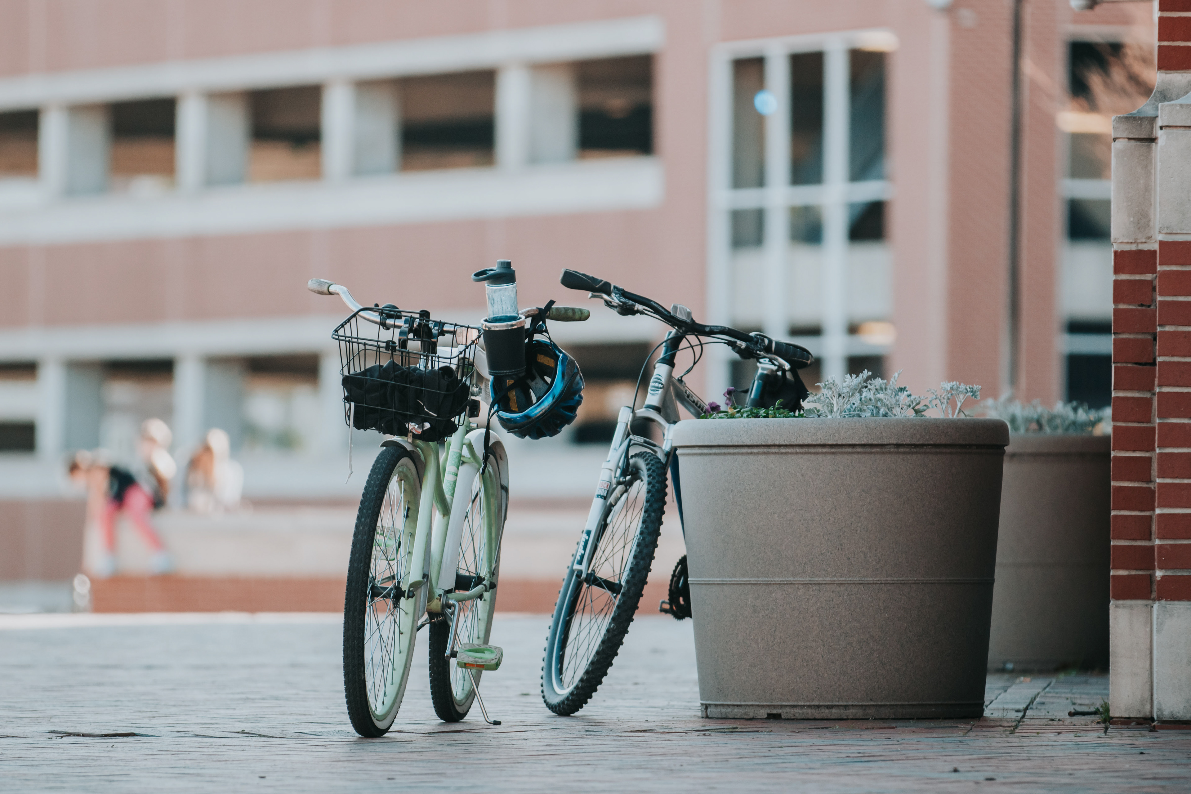 students' bikes leaned against a planter near the bus stop