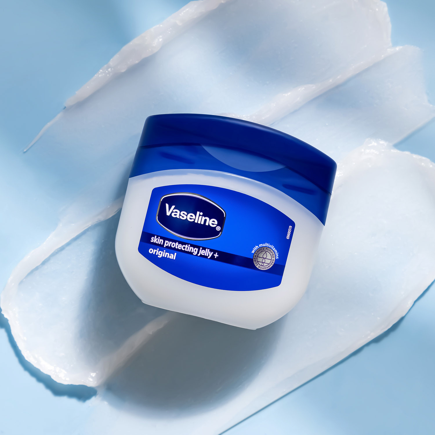 Vaseline Skin Protecting Jelly Original on a blue background with texture swatch