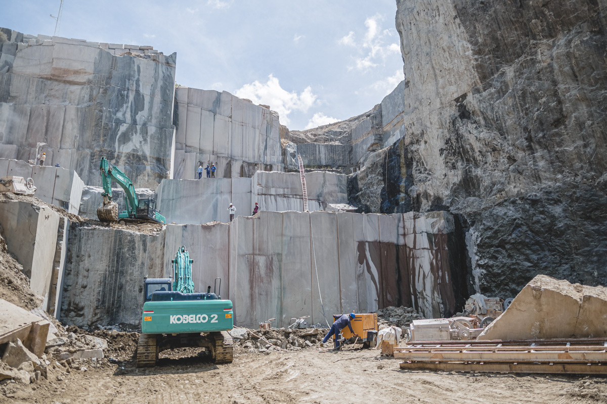Excavator preparing to break huge piece of stone