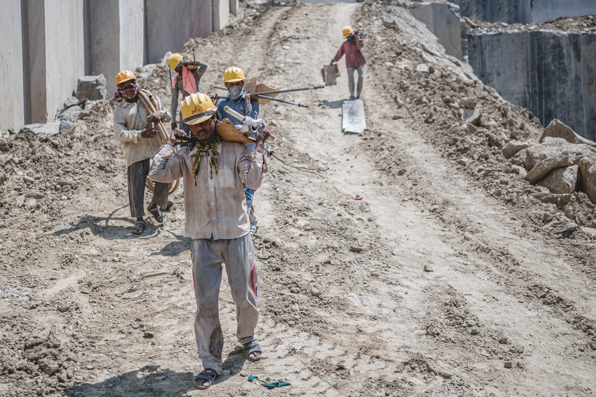 Quarry workers moving equipments on a downhill