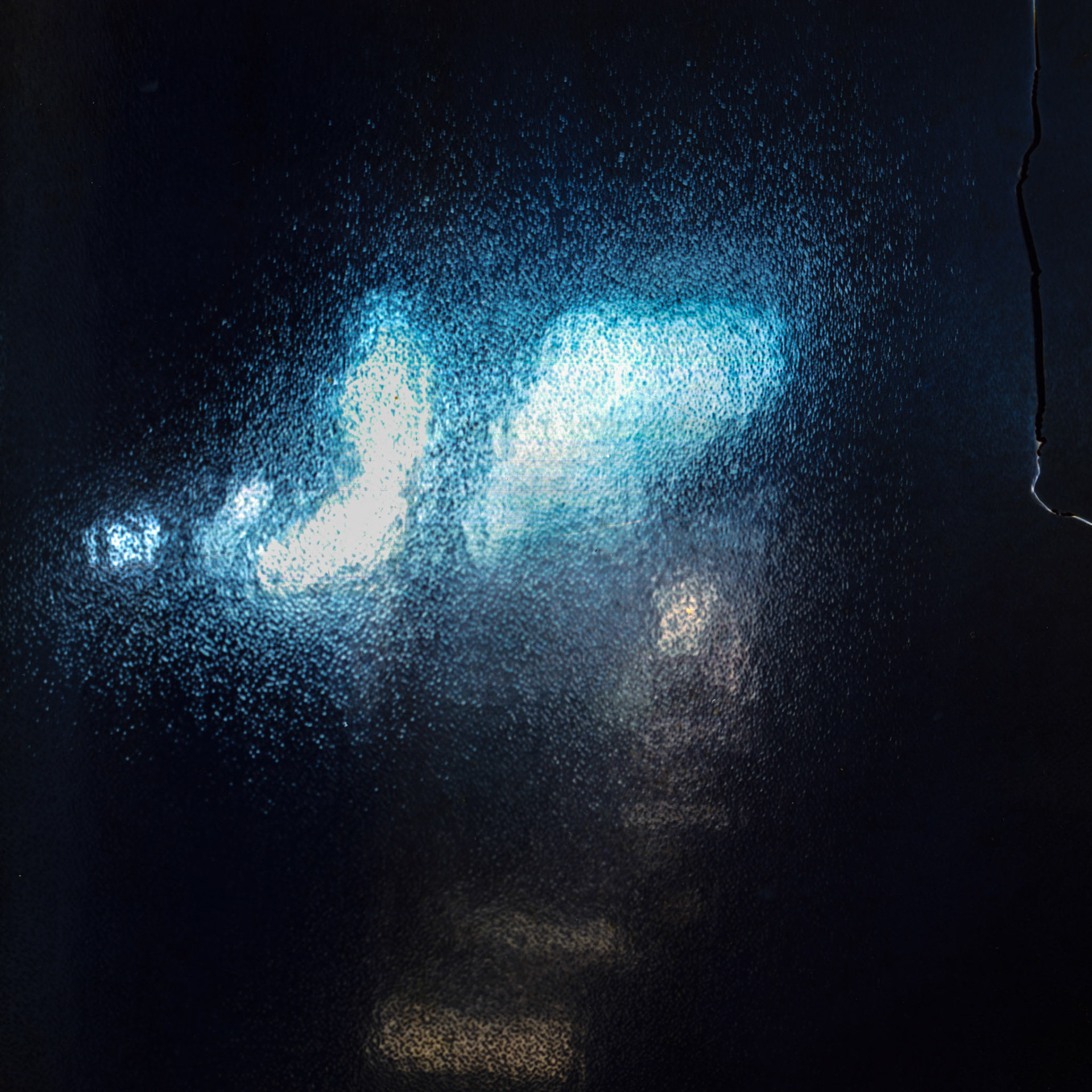 An opaque and cracked surface with a bluish light emerging, symbolizing distance and isolation.