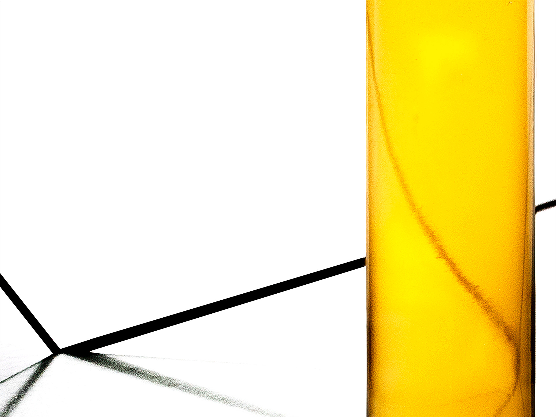 Abstract photograph with a vivid yellow column on a white background crossed by black oblique lines, in visual and silent balance.