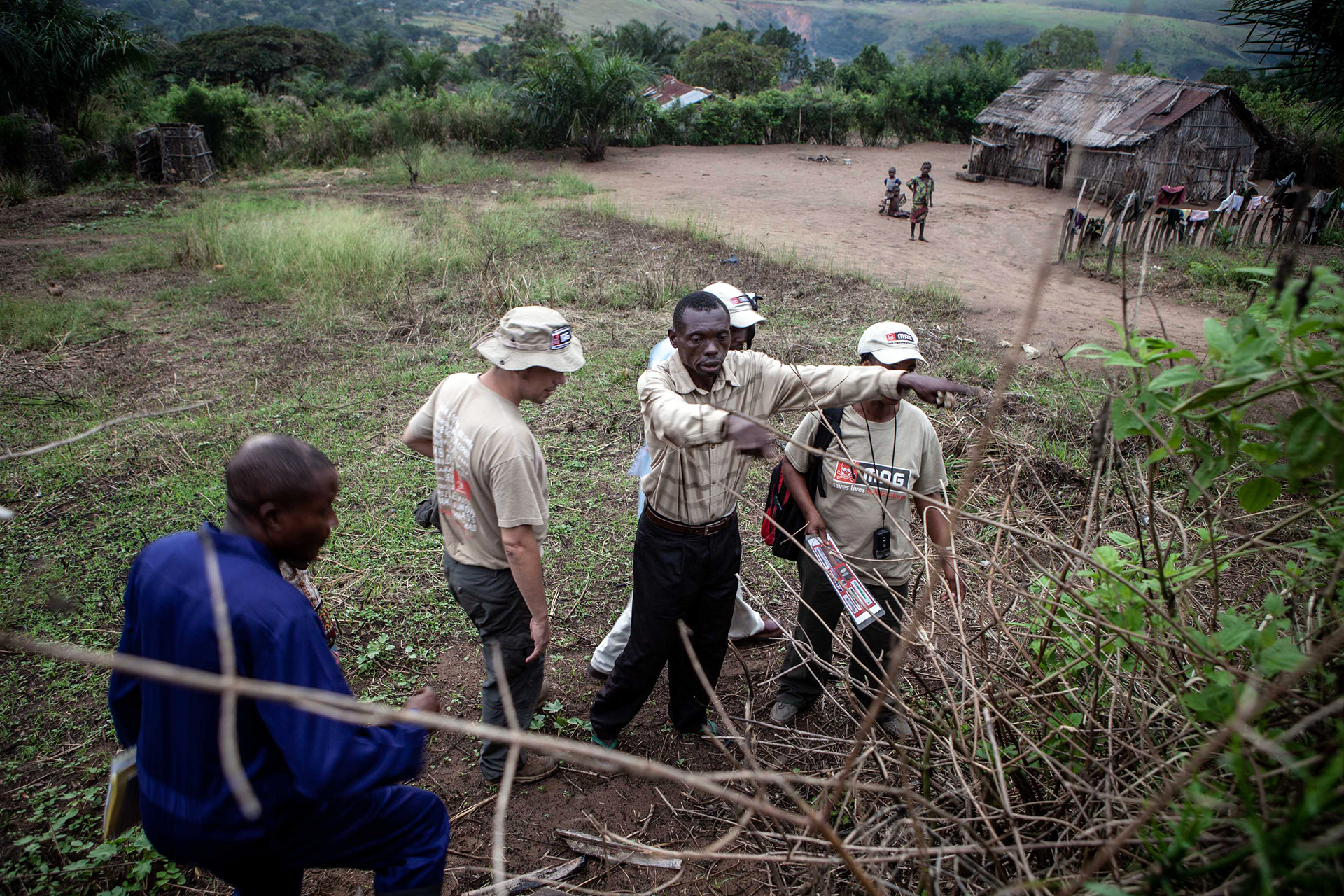 A resident of Kenge indicates to MAG Community Liaison team the location of a RPG (Rocket Propelled Grenade), buried here several years ago.