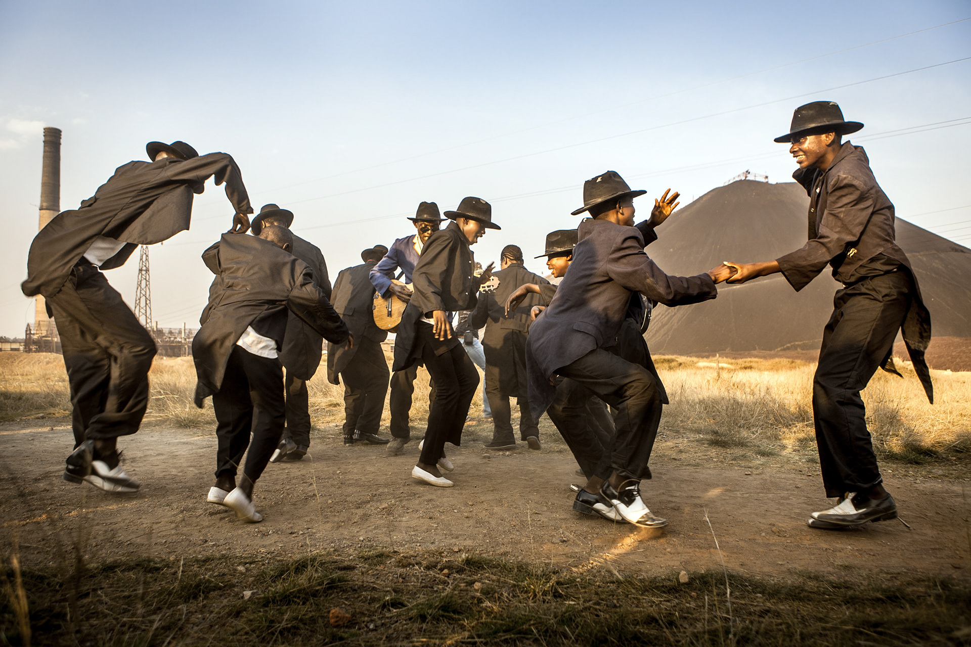 The Jecoke, (from left to right : Tresor Kaluw, Fostin Lukwesa, Maty Mambu, Manix Kavunda, Andy Monga) are performing in front of « Lubumbashi factory », characterized by its chimney and the hip slag, symbols of the city of Lubumbashi.