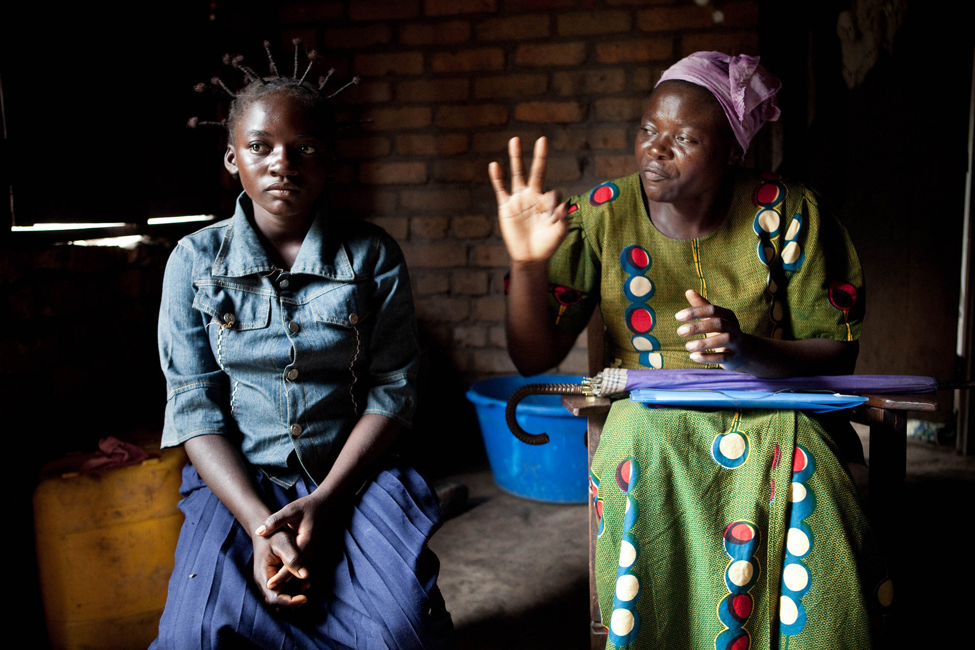 An activist of the association AFPDE (right) is interviewing a 15 years old girl named Kyungu (left). She was repeatedly raped by her neighbour in Uvira, a boy of the same age. "The family of the rapist tried everything to obtain an amicable arrangement. My mother (right) eventually gave in in return for the payment of the maternity costs and the reimbursement of school expenses, as I cannot go to school any more. Now, I have to live with him. I even have to sleep with him... I am ashamed and I am afraid. I am just a child but my parents want him to marry me. They are ashamed to keep a pregnant girl with them."