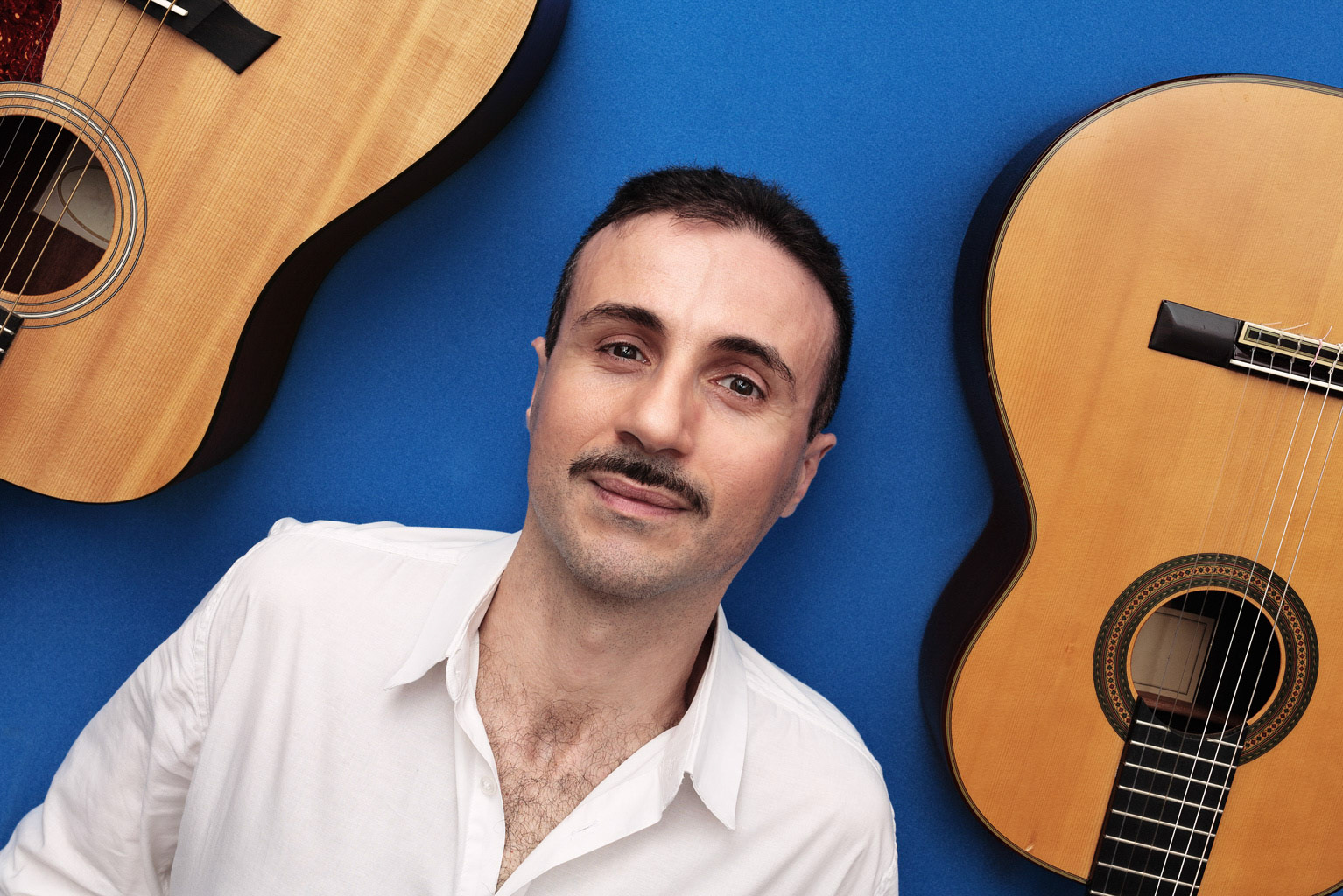 guitarist lies down between his two instruments