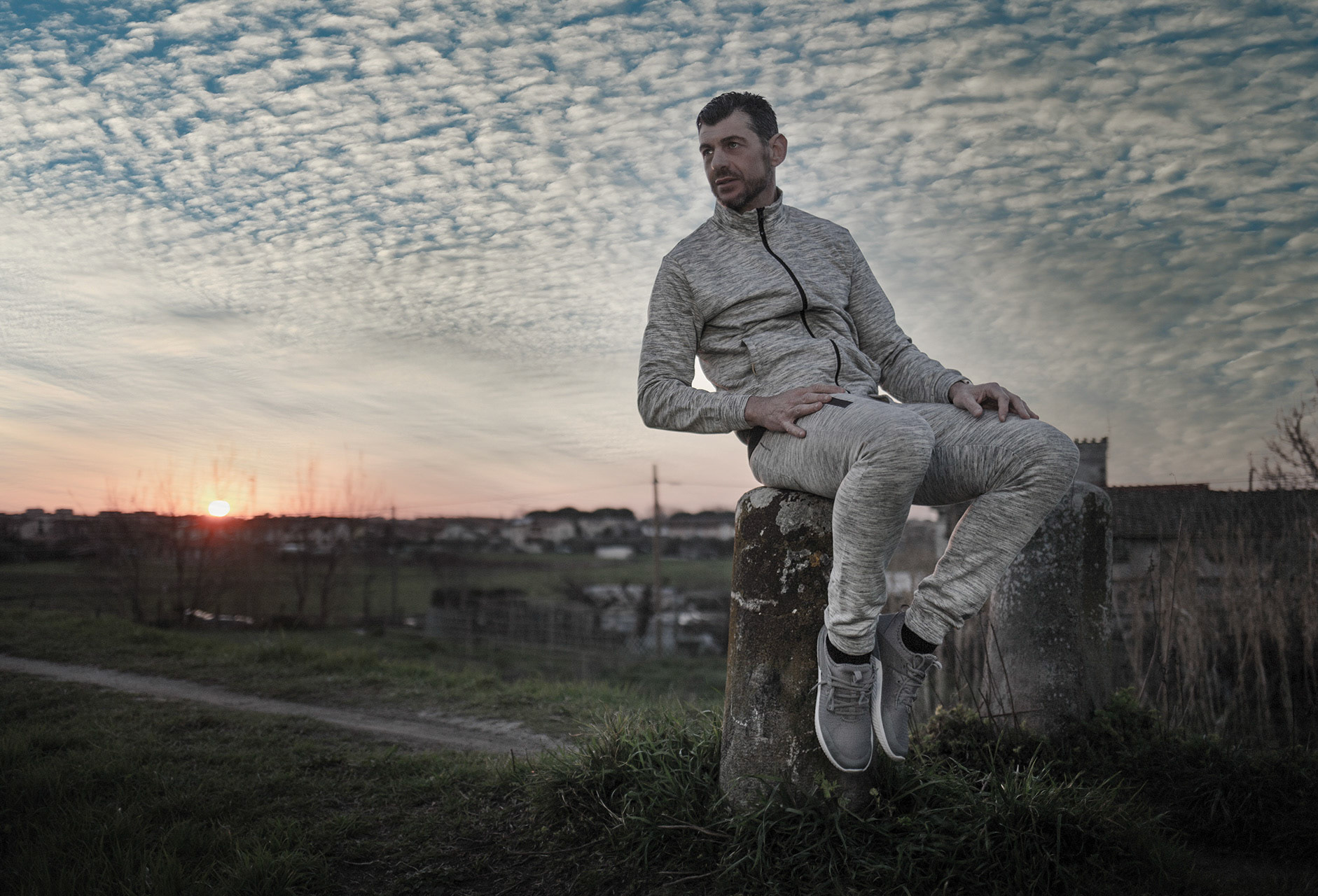 visibly satisfied, an athlete sits in the nature for the break on a post