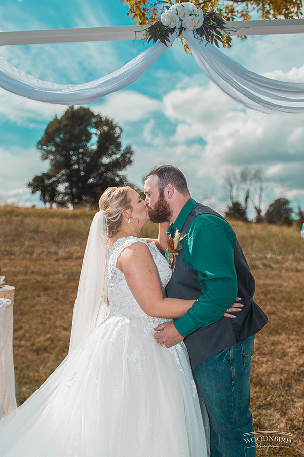 Couple beneath blue-draped arch