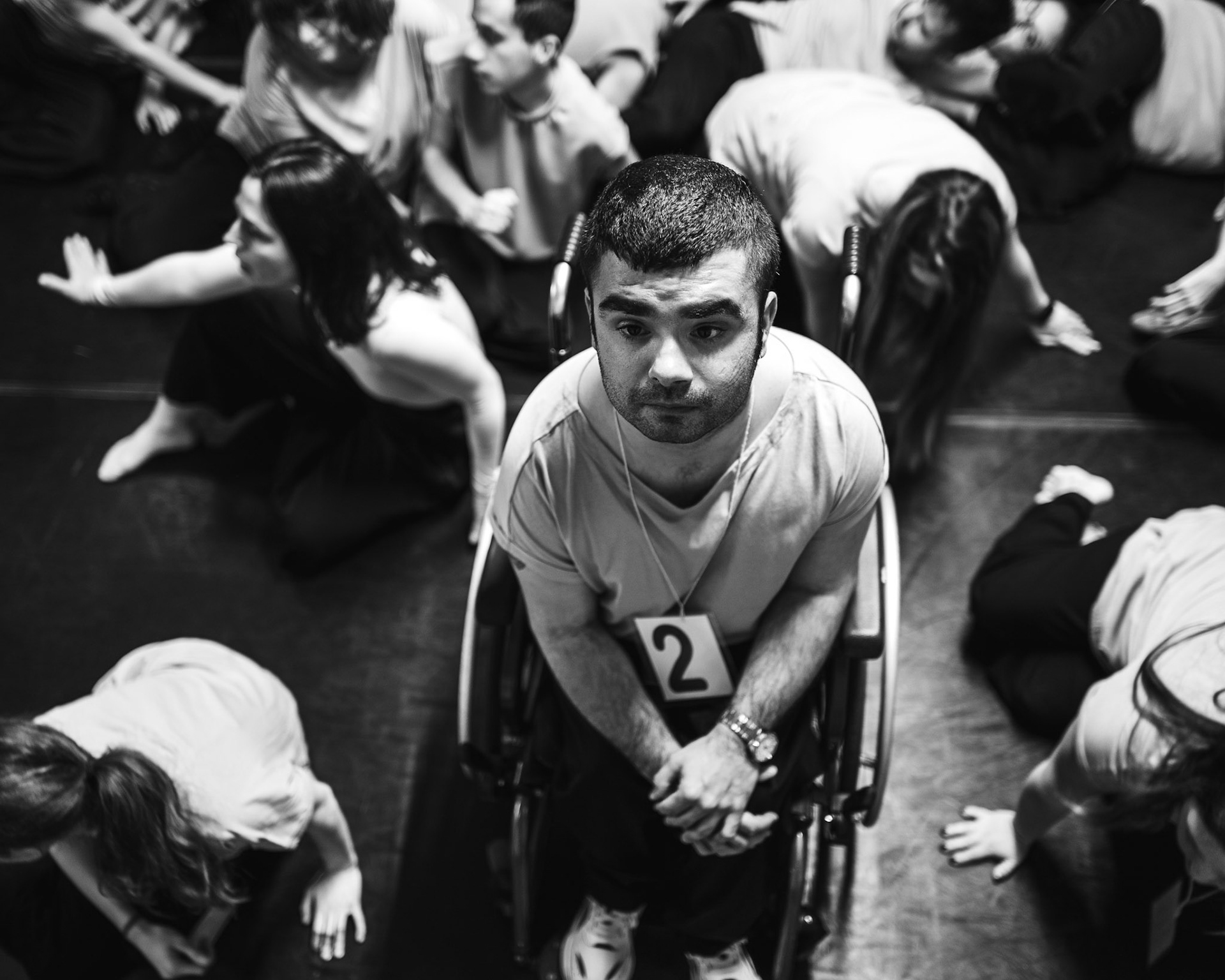 Scena corale di spettacolo teatrale inclusivo con luci calde e forte espressività