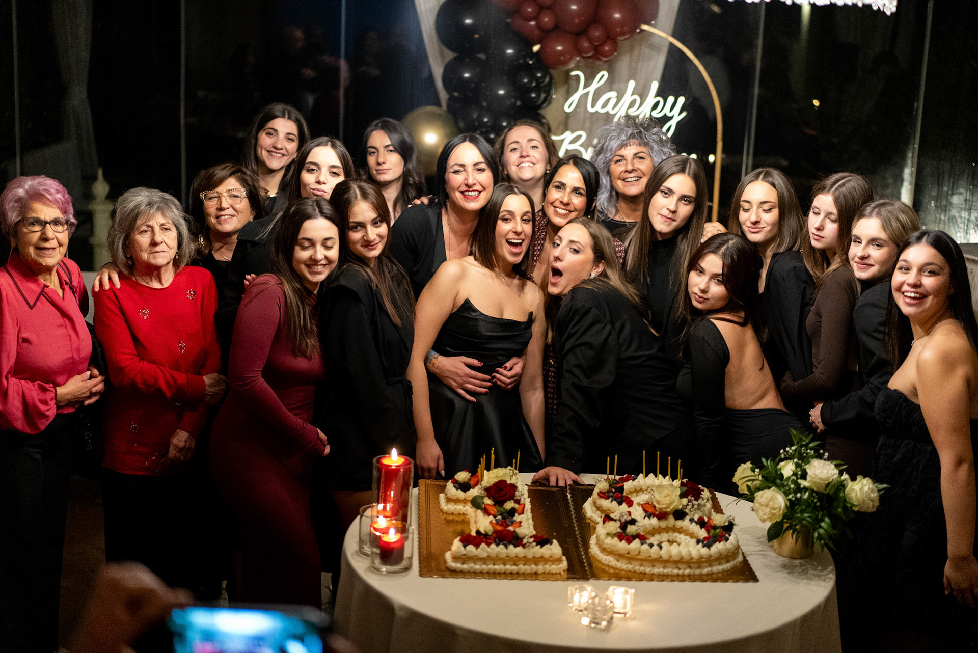 Foto di gruppo durante evento elegante, luce calda e atmosfera intima.