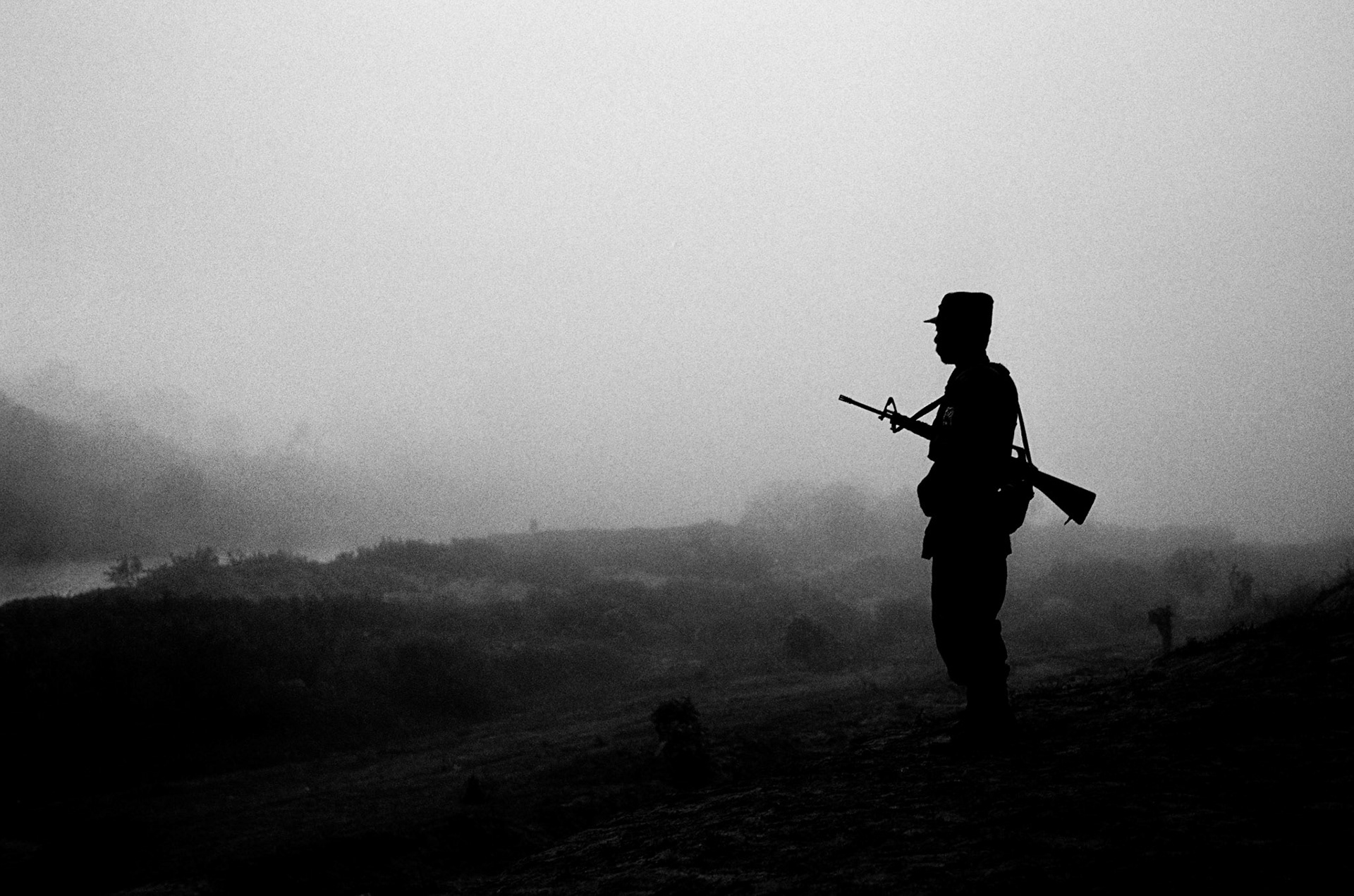 A soldier from the Karen National Liberation Army (KNLA) looking out over the Moie river keeps watch at the headquarters of 7th Brigade in Karen State, Burma.