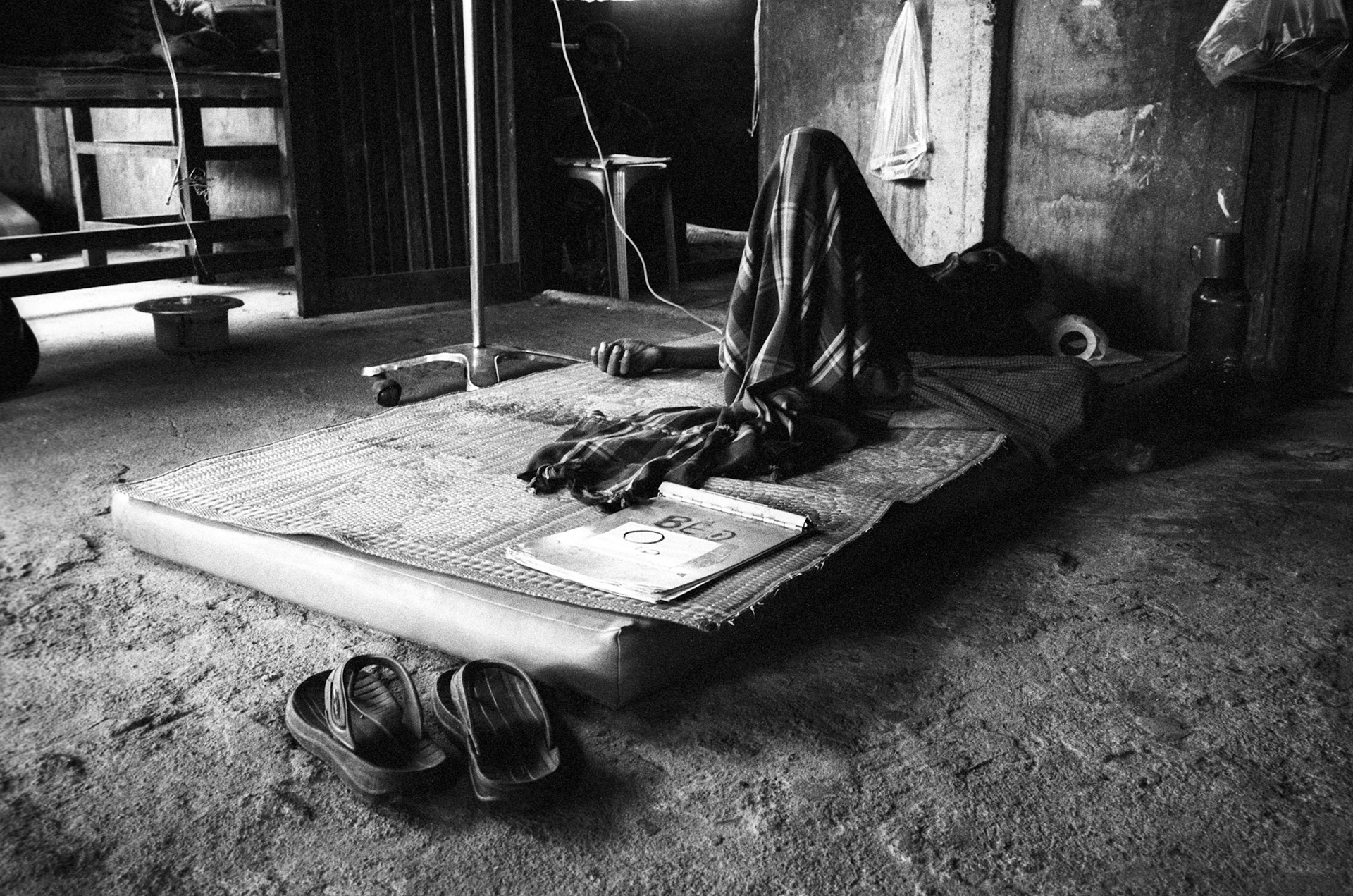 A man lies severely ill from malaria in the in-patient ward at the Mae Tao Clinic on the Thai-Burma border. Approximately 300 people per day receive free healthcare at the clinic, mostly being migrant workers and refugees who have fled across the border from Burma (Myanmar) to escape the desperate poverty and persecution from the ruling military regime. Healthcare is all but non-existent in Burma, where less than 2% of the GDP is spent on healthcare and education combined.