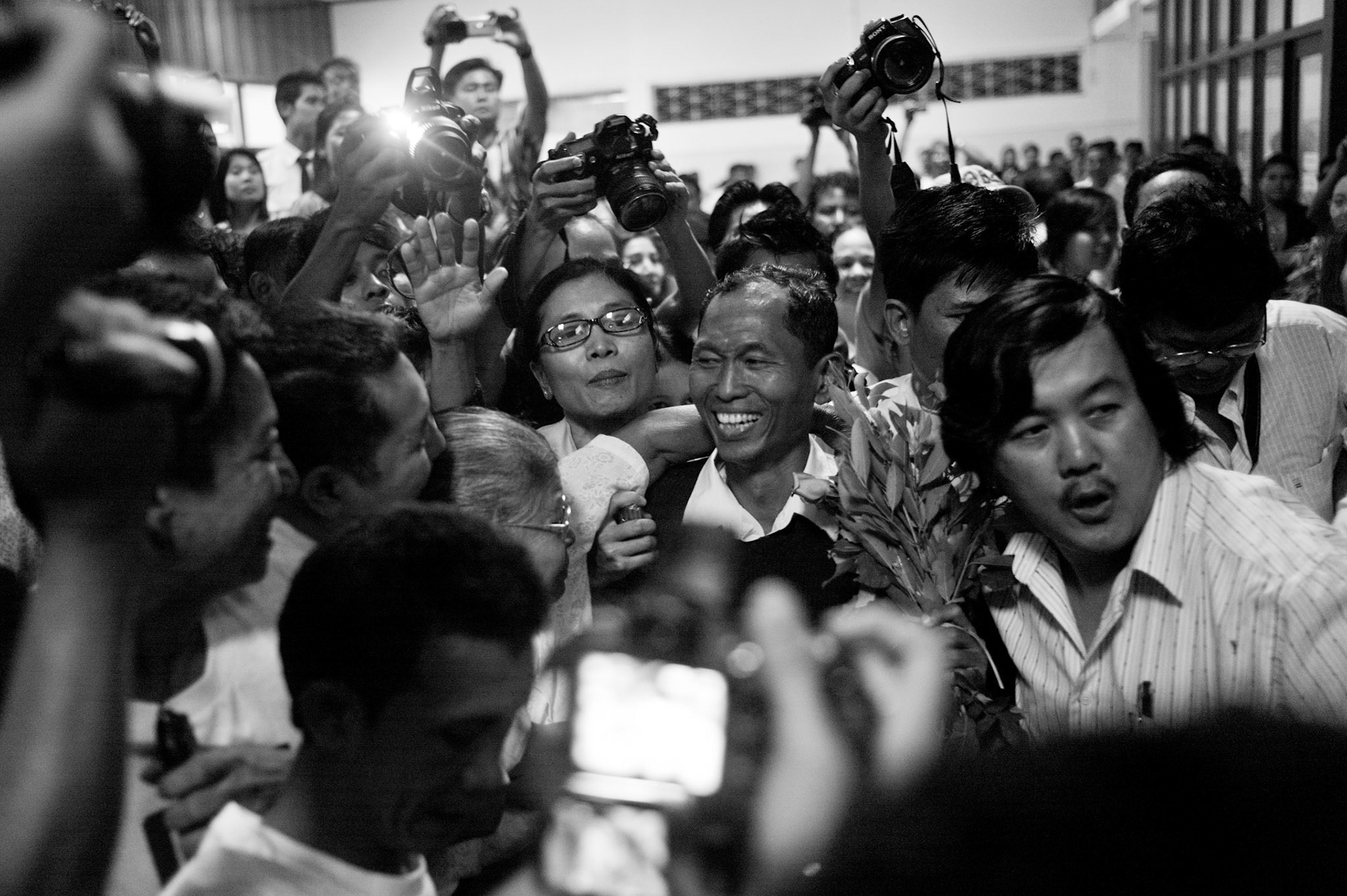 One of Burma's most prominent politial dissidents, 88 Generation Student leader Ko Ko Gyi is mobbed by hundreds of well wishers and dissidents as he arrives in Rangoon airport having been released from prison where he was serving a 65 year sentence. The Presidential amnesty saw more than 600 political prisoners released from prison, many of who were former leaders of the mass democracy uprising in 1988 and were serving long sentences of 65 years or more.