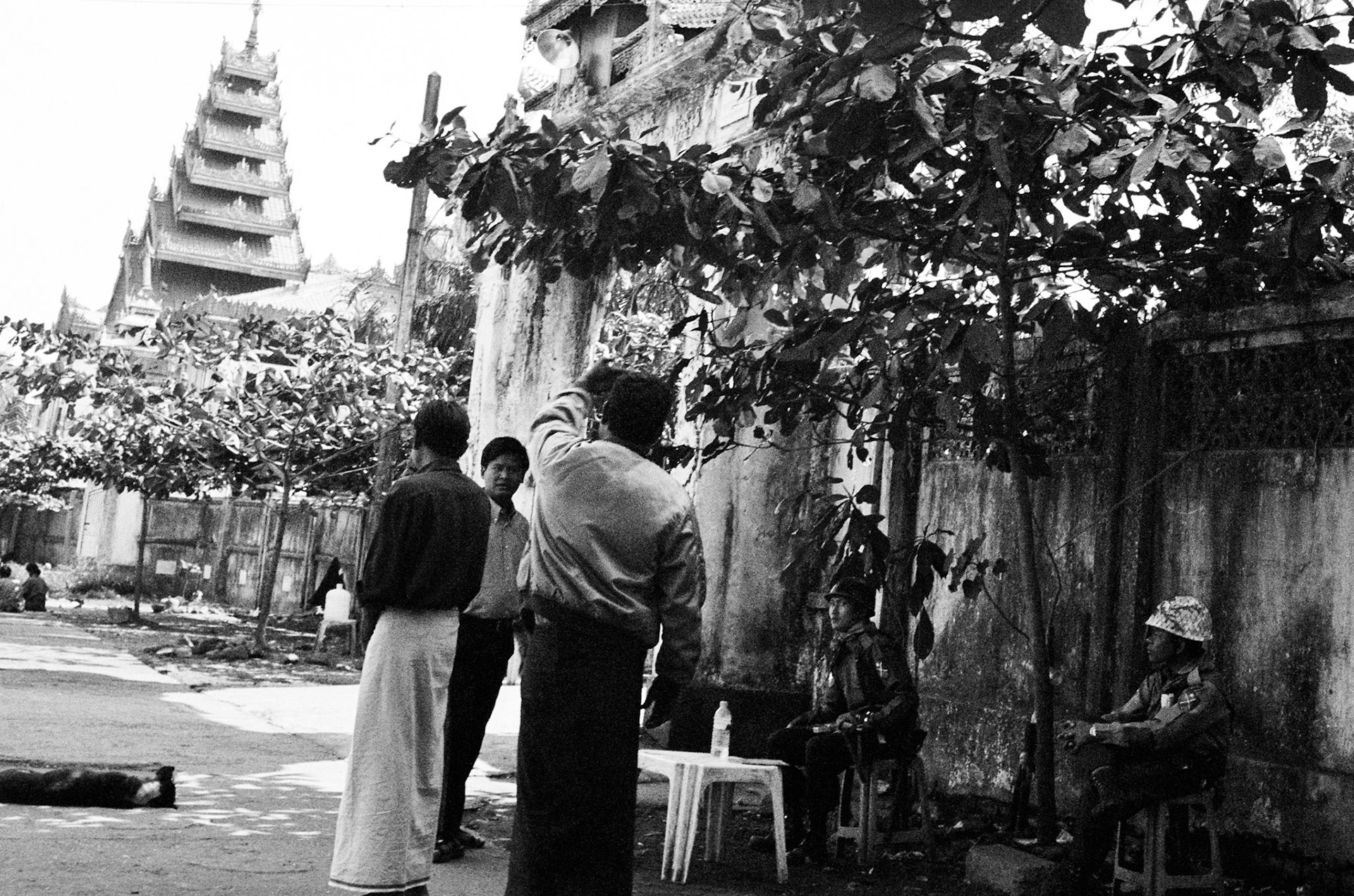Military Intelligence officers and riot police outside a monastery that was raided during the monk led Saffron Revolution a month earlier and is now under the control of the authorities