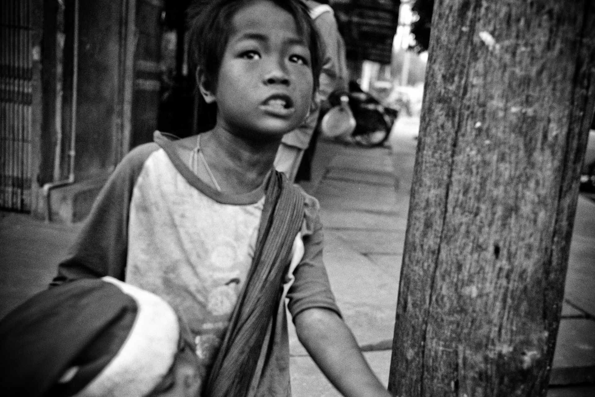 A young homeless boy carrying his younger brother begs on the streets of Mandalay. Burma, a resource rich nation, has become one of the poorest in the world with estimated more than 30% of the population living on or below the poverty line and where the ruling military regime spend less than 2% of GDP on education and healthcare combined.