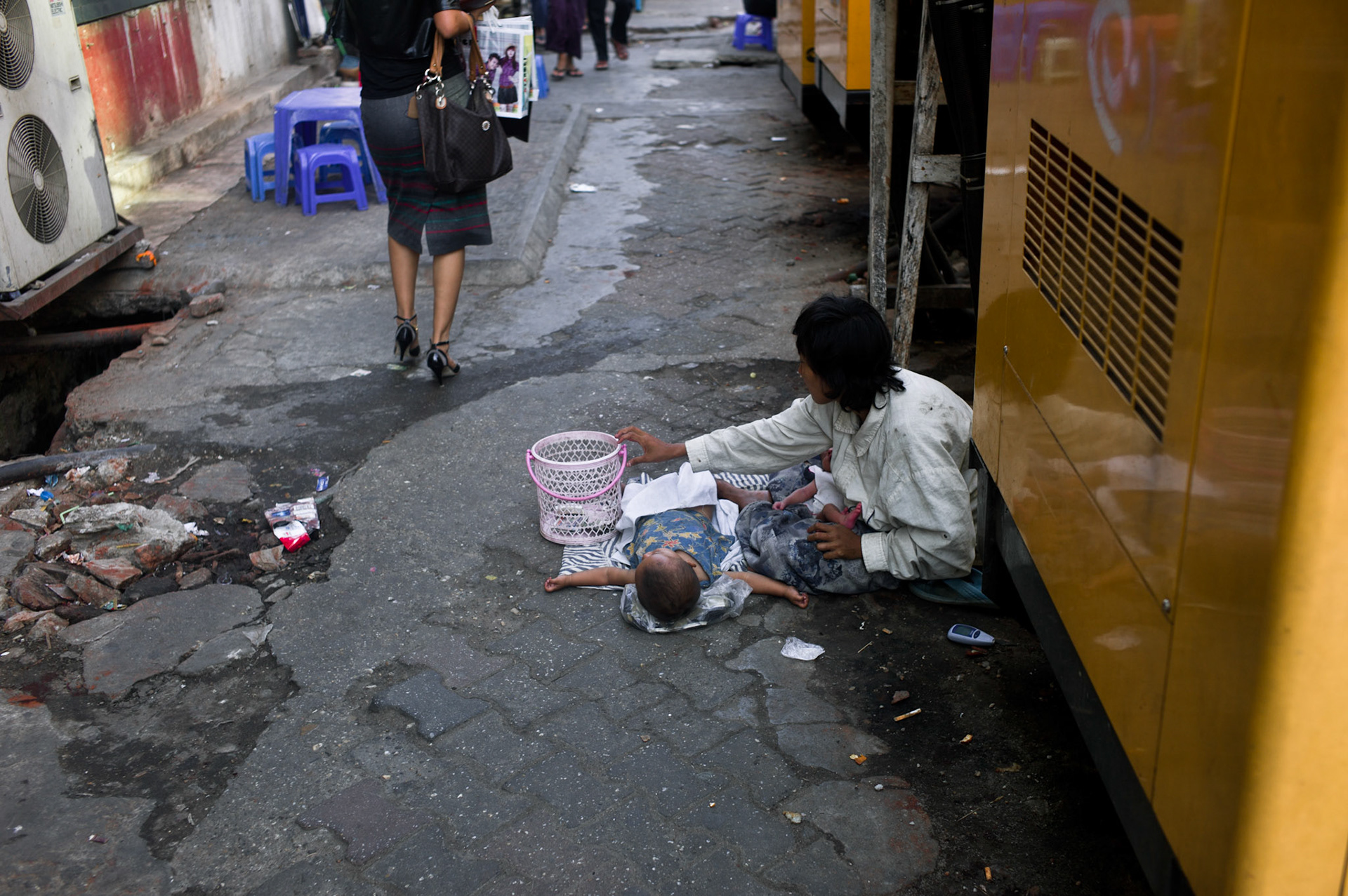 A mother with her two young children begs on the streets of downtown Rangoon as a well-heeled lady walks by. Over the past few years a shift in society has developed in Burma with the emergence of a 'wealthy class' however the country is still poverty stricken with many surviving on no more than $1 per day. Burma, a resource rich nation, has become one of the poorest in the world with estimated more than 30% of the population living on or below the poverty line and where the ruling military regime spend less than 2% of GDP on education and healthcare combined.