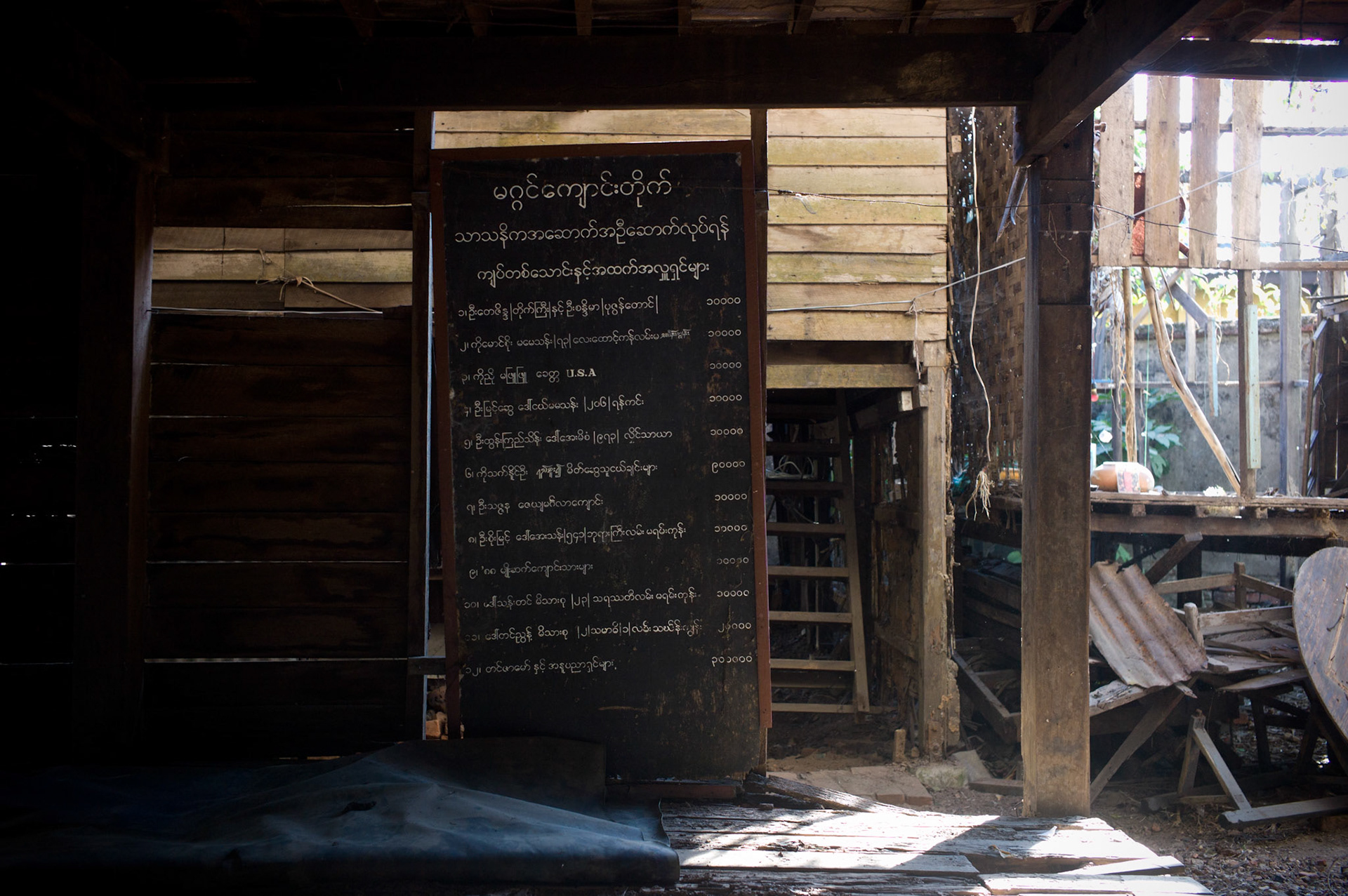 A board listing donations made to the monastery is temporarily propped up against a wall having been torn down by soldiers. On September 26th 2007, at the height of Burma's monk led Saffron Revolution, Maggin Monastery in Rangoon, was raided as the regime commenced its brutal crackdown on the protests. On 13th January 2012 the monks were released from prison and more than four years since the monastery was raided and locked, they returned and opened the doors once more. Everything they found was exactly as it was left the night the military regime arrested them and ransacked the buildings.