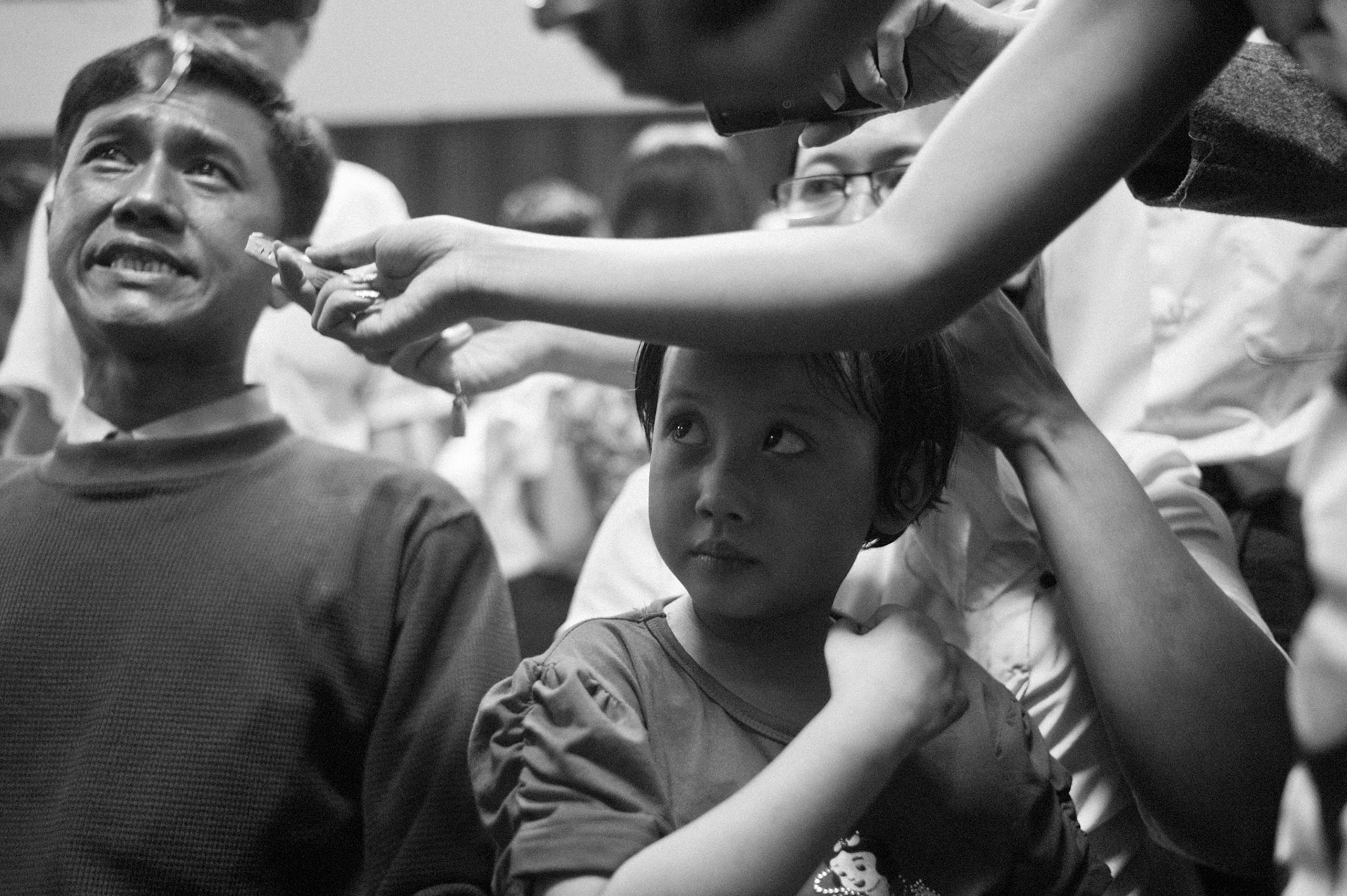 Phyu Nay Kyi watches as her father Ko Jimmy is interviewed by waiting media. Reunited after being released from prison under a presidential amnesty, husband and wife, Ko Jimmy, Nilar Thein and Phyu Nay Chi are a family once again. The Presidential amnesty saw more than 600 political prisoners released from prison, many of who were former leaders of the mass democracy uprising in 1988 and were serving long sentences of 65 years or more.