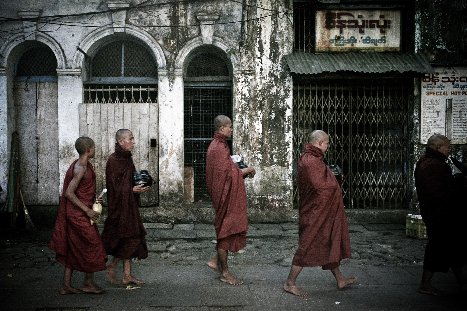 As day breaks each morning monks walk through the streets of downtown Rangoon collecting their alms. Buddhism plays a vital role in Burmese culture and society.