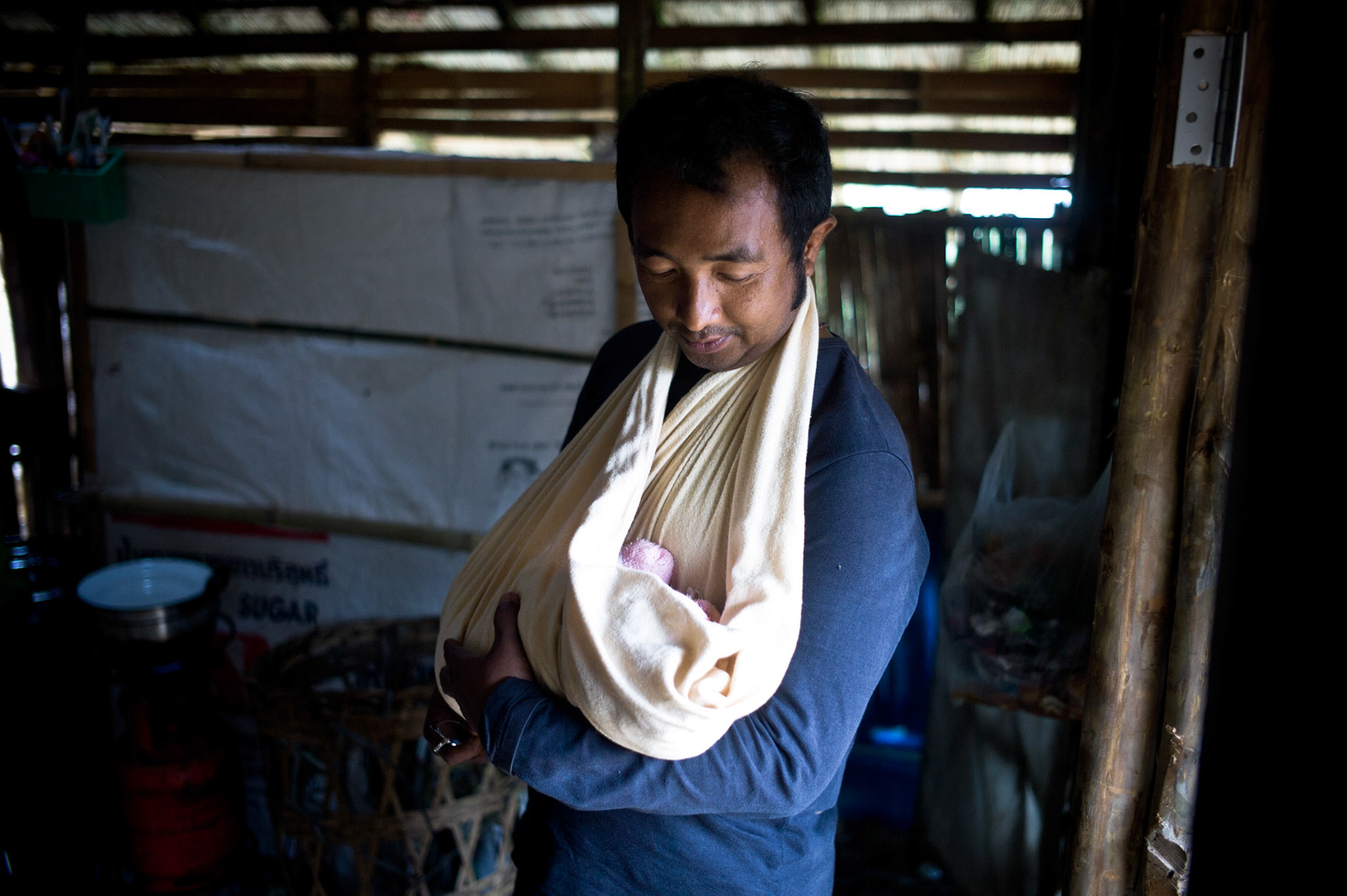 Soe Myint cradles his newborn baby at home in Umpiem Mai refugee camp on the Thai-Burma border. He fled Burma after his release from prison where he was jailed for 3 years for his political activities.